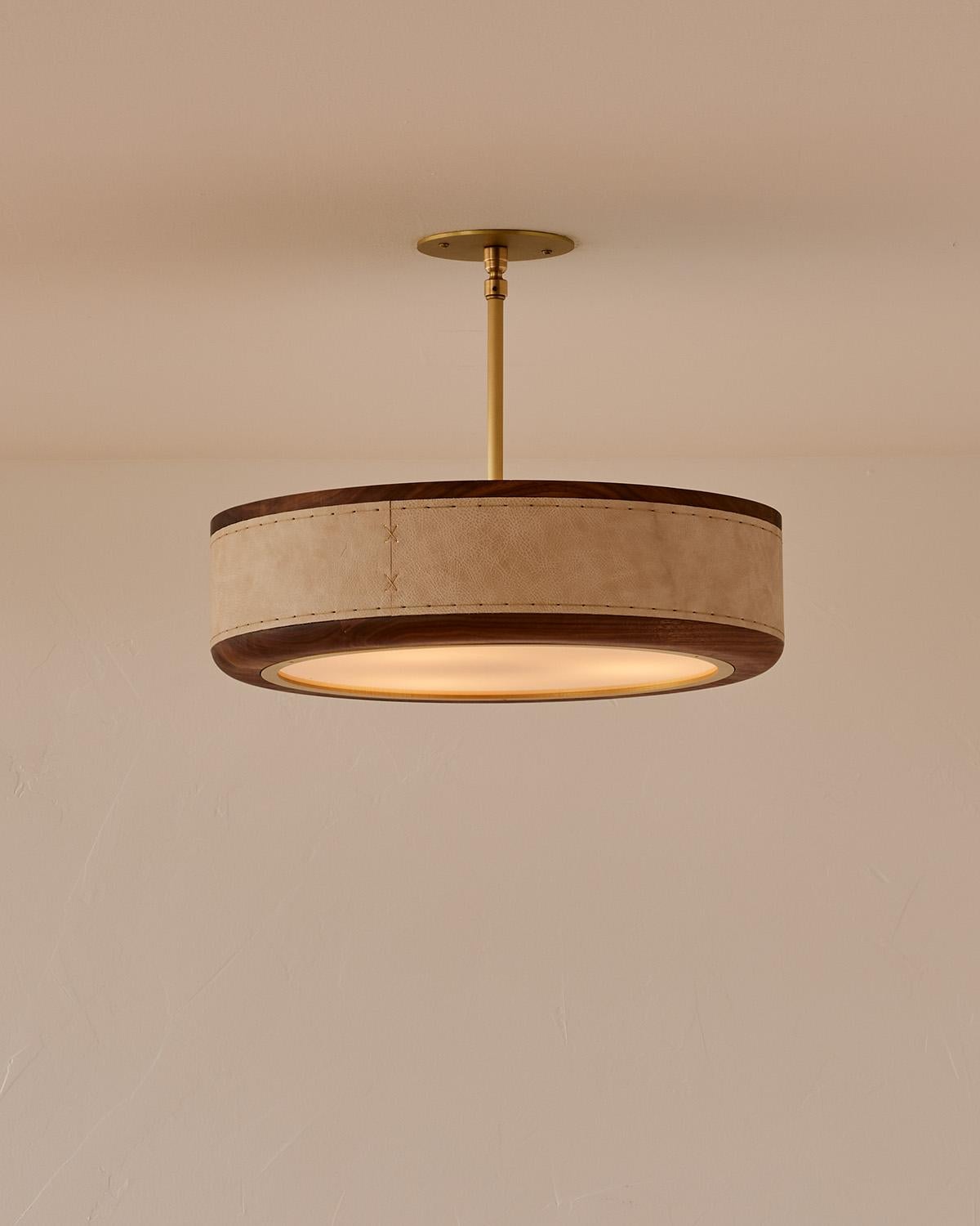 The Nura Ceiling Fixture combines hand-stitched leather over walnut accented by a brass pole and canopy. This fixture can either be hung as a ceiling surface mount or a pendant supported by a brass pole.

OVERALL DIMENSIONS
Shade: 18