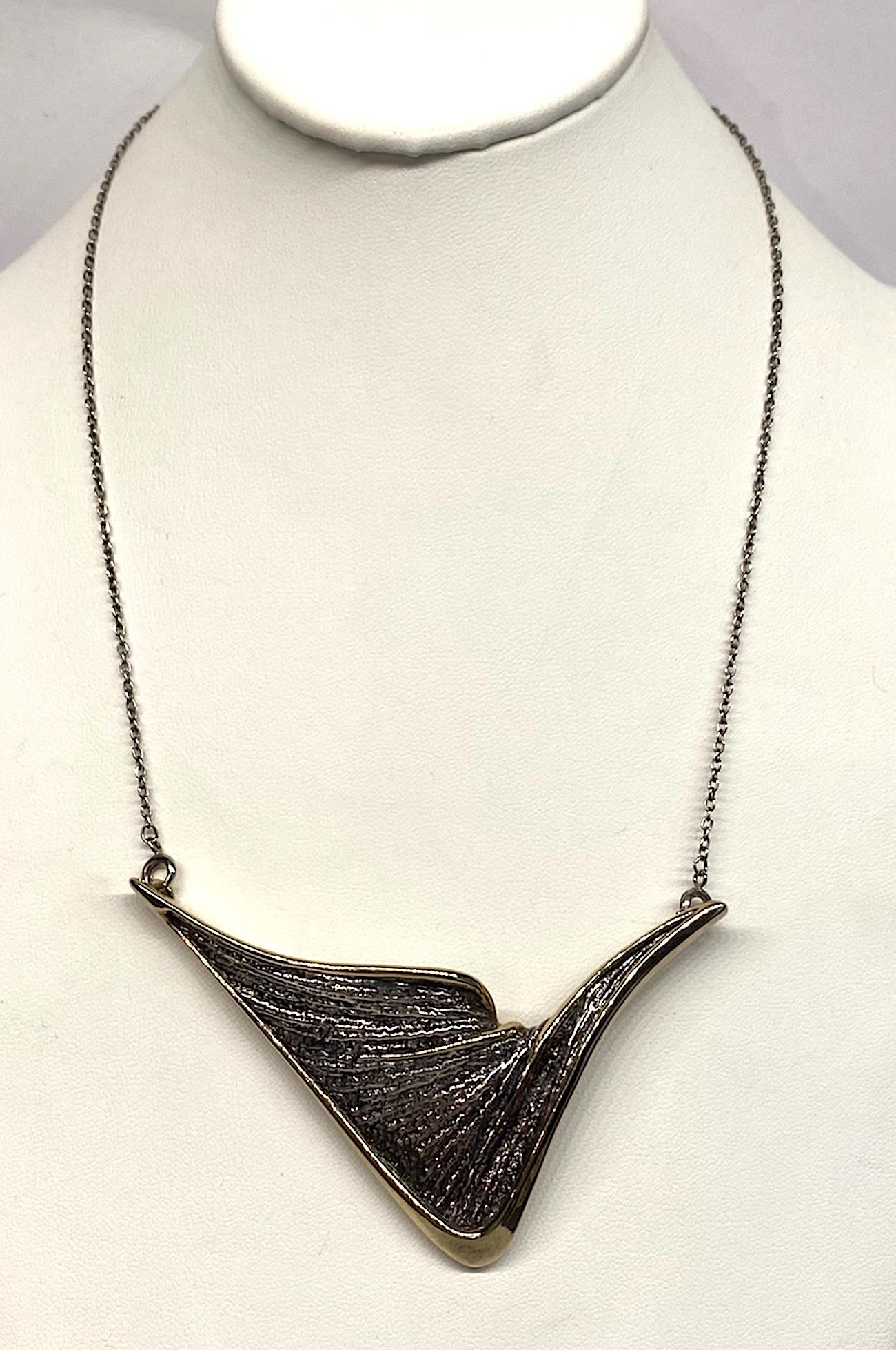 A wonderful abstract patinated and gilt sterling silver pendant necklace. The sweeping V form pendant is beautifully cast in wax first and patinated in the grooves. It is not heavy as pendant is hollow except for was. The edges are gold plated. The