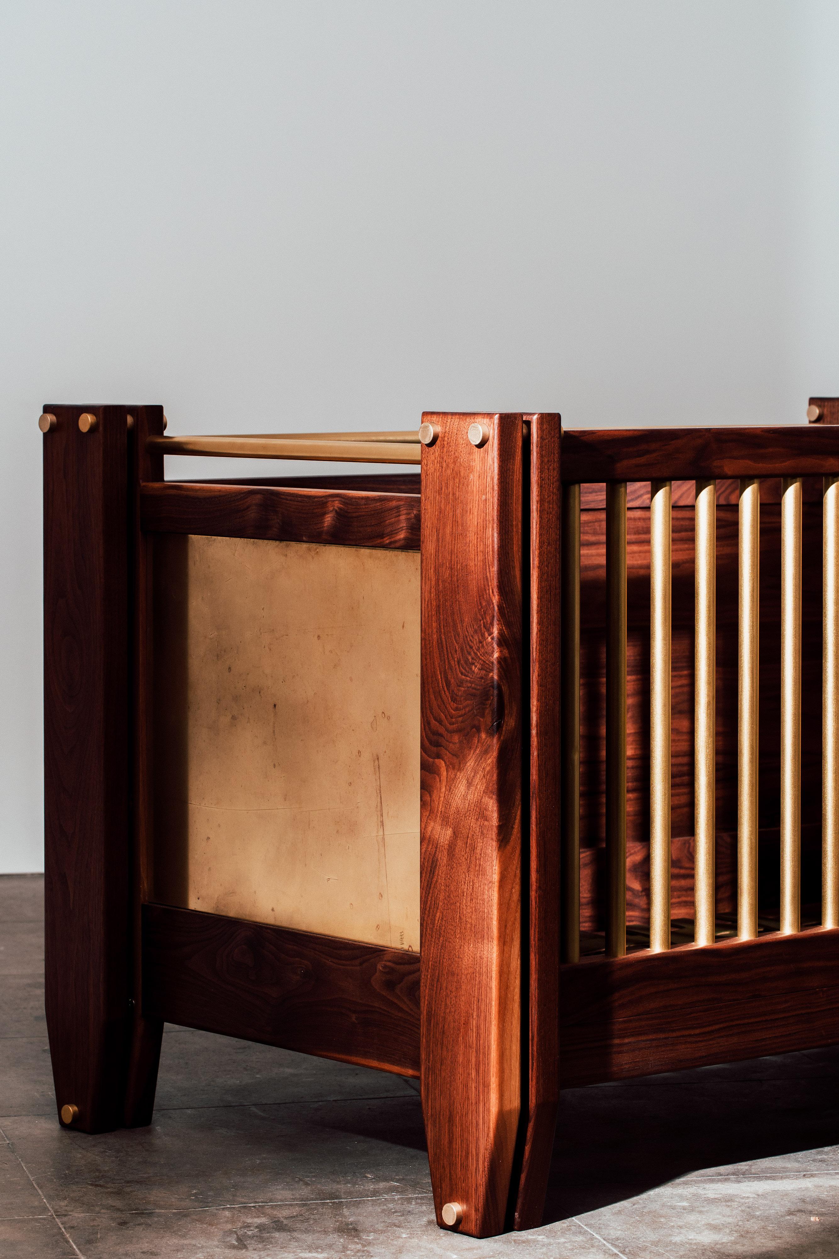 A crib like no other. This crib features a three in one system from infant to toddler bed. Simply remove the side posts and take out and adjust to your specifications in your child's life. Solid black walnut, milled brass component and hand dyed