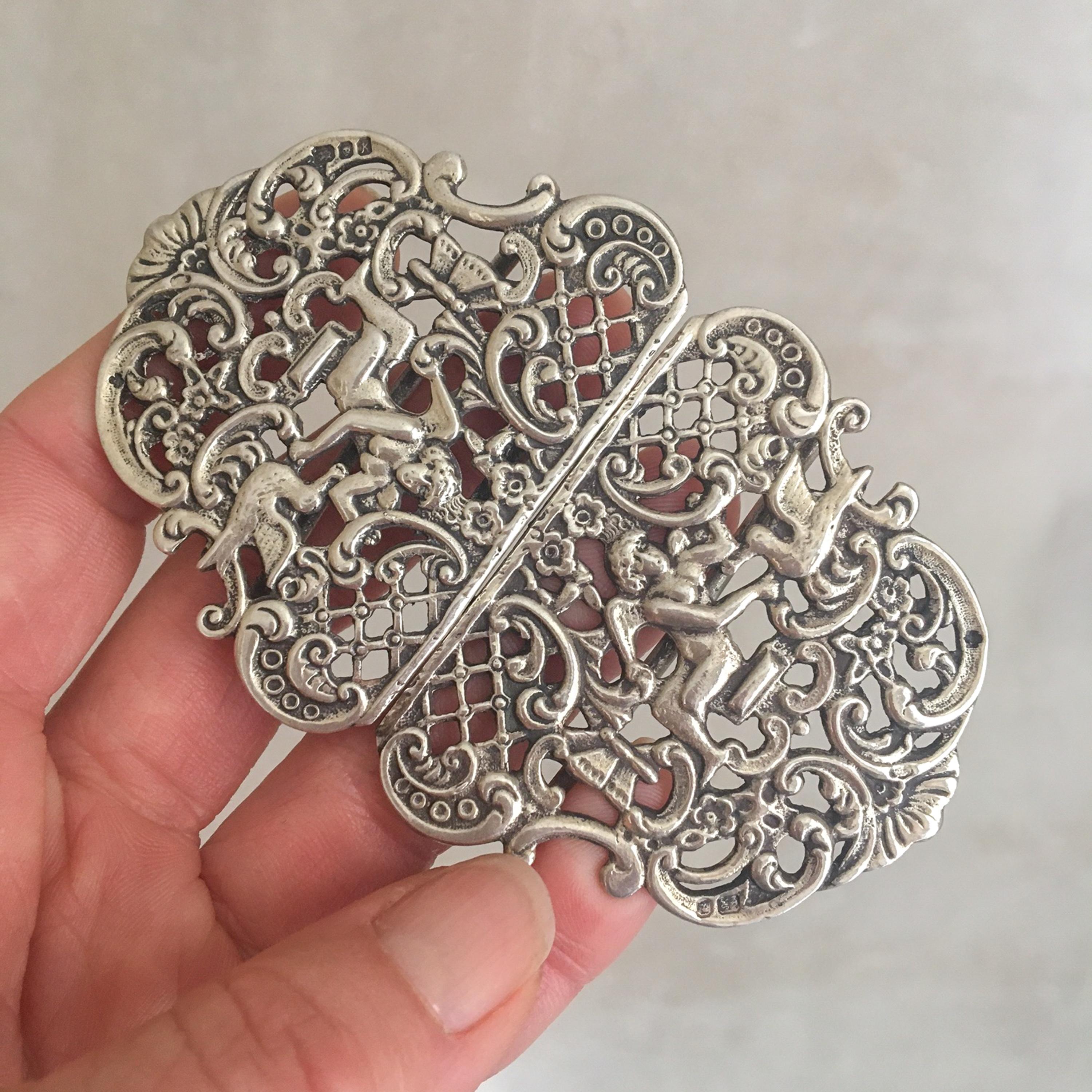 Nurses buckle made out of sterling silver which shows a beautiful opulent presentation. The belt buckle has a scrolling openwork design, depicting a bird with winged angels. The buckle is stamped with full London Hallmarks, Lion, Leopard and date