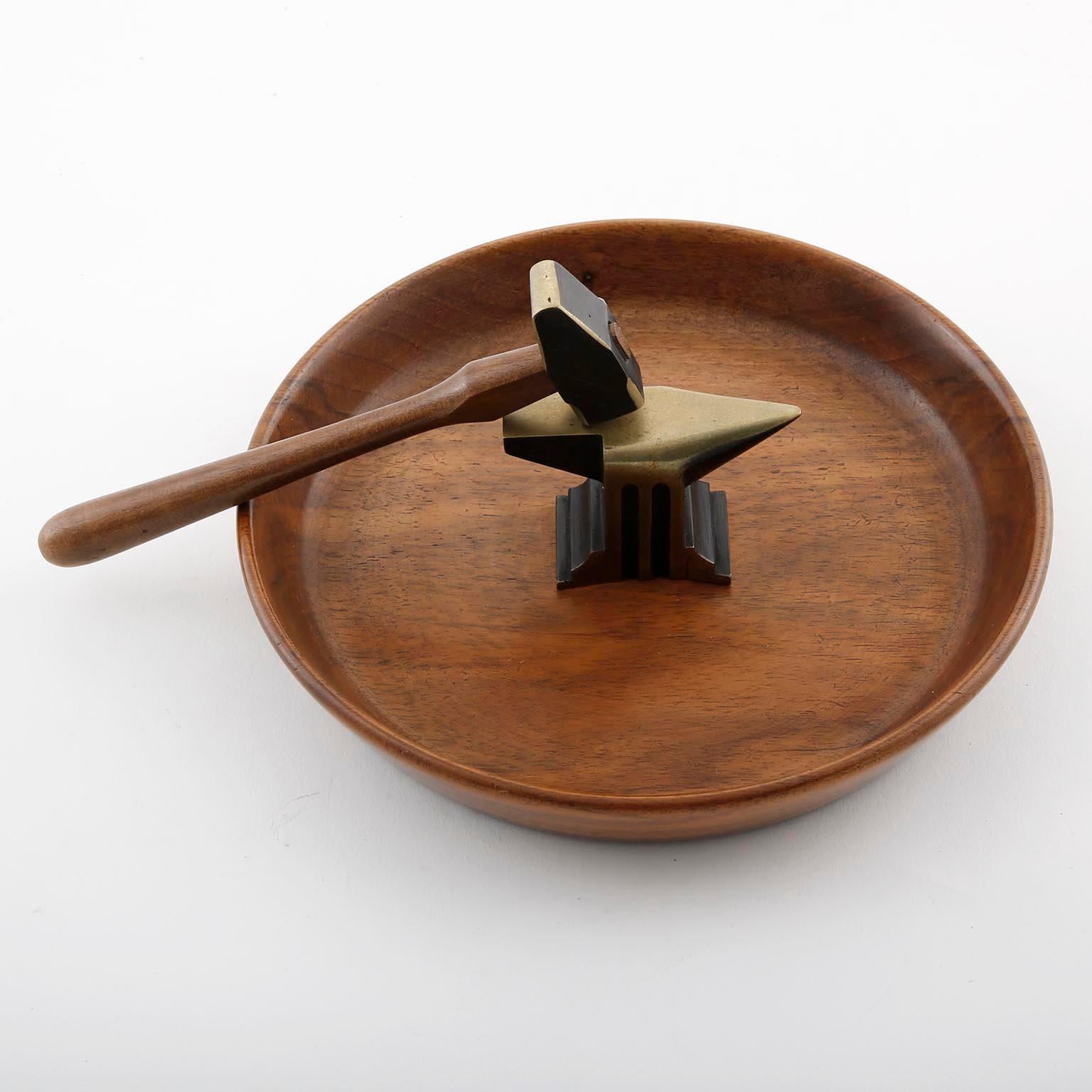 A Mid-Century Modern nutcracker set consists of an organic shaped nutwood bowl and a blackened solid brass amboss with hammer, designed by Richard Rohac, manufactured in Vienna, Austria, circa 1950.