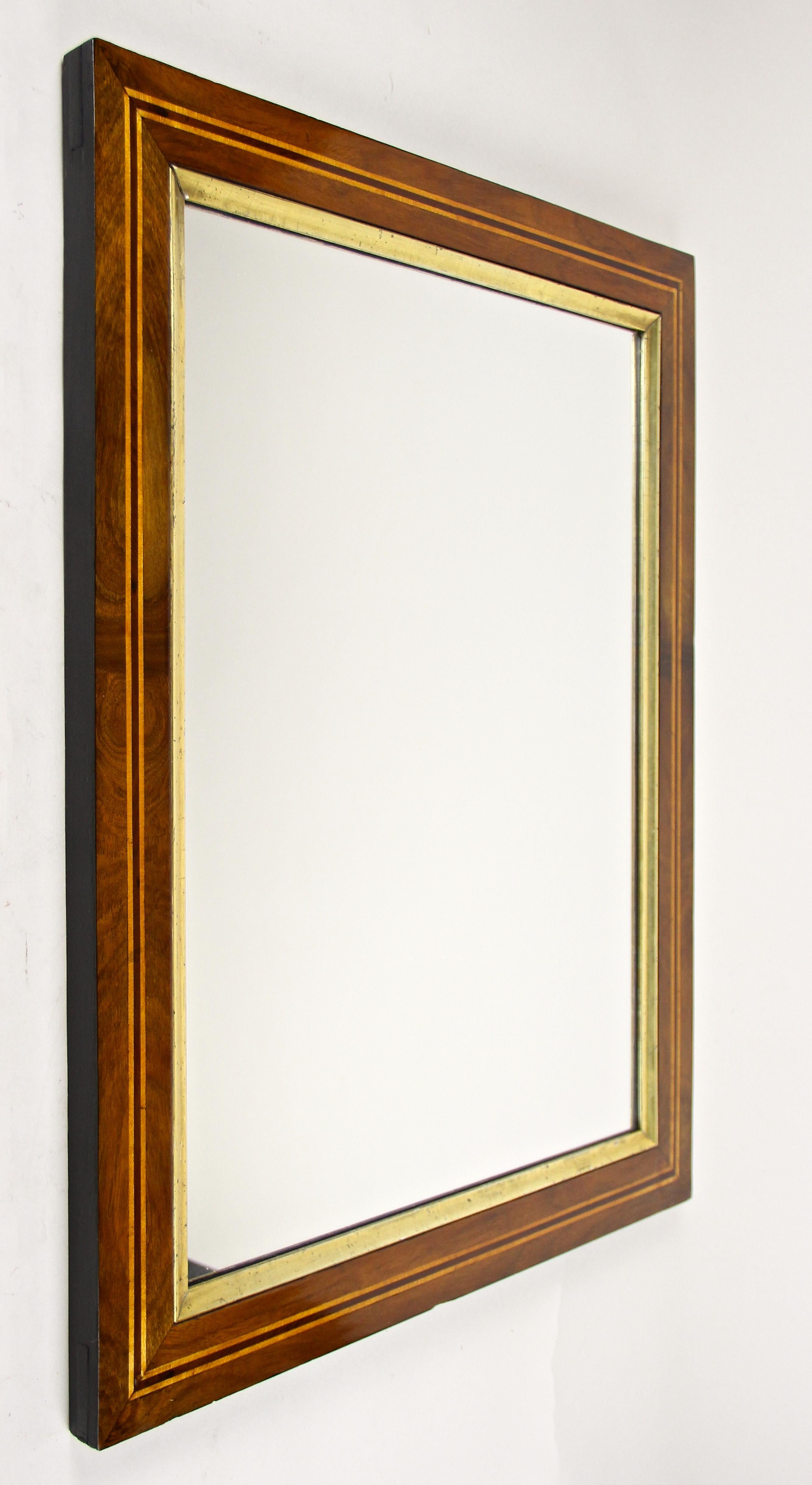 Superb 19th century nutwood wall mirror from the famous Biedermeier period circa 1840 in Austria. The frame built of spruce wood with an overlapping inserted sub-structure, shows a beautiful thick nut wood veneered surface. An additional, very