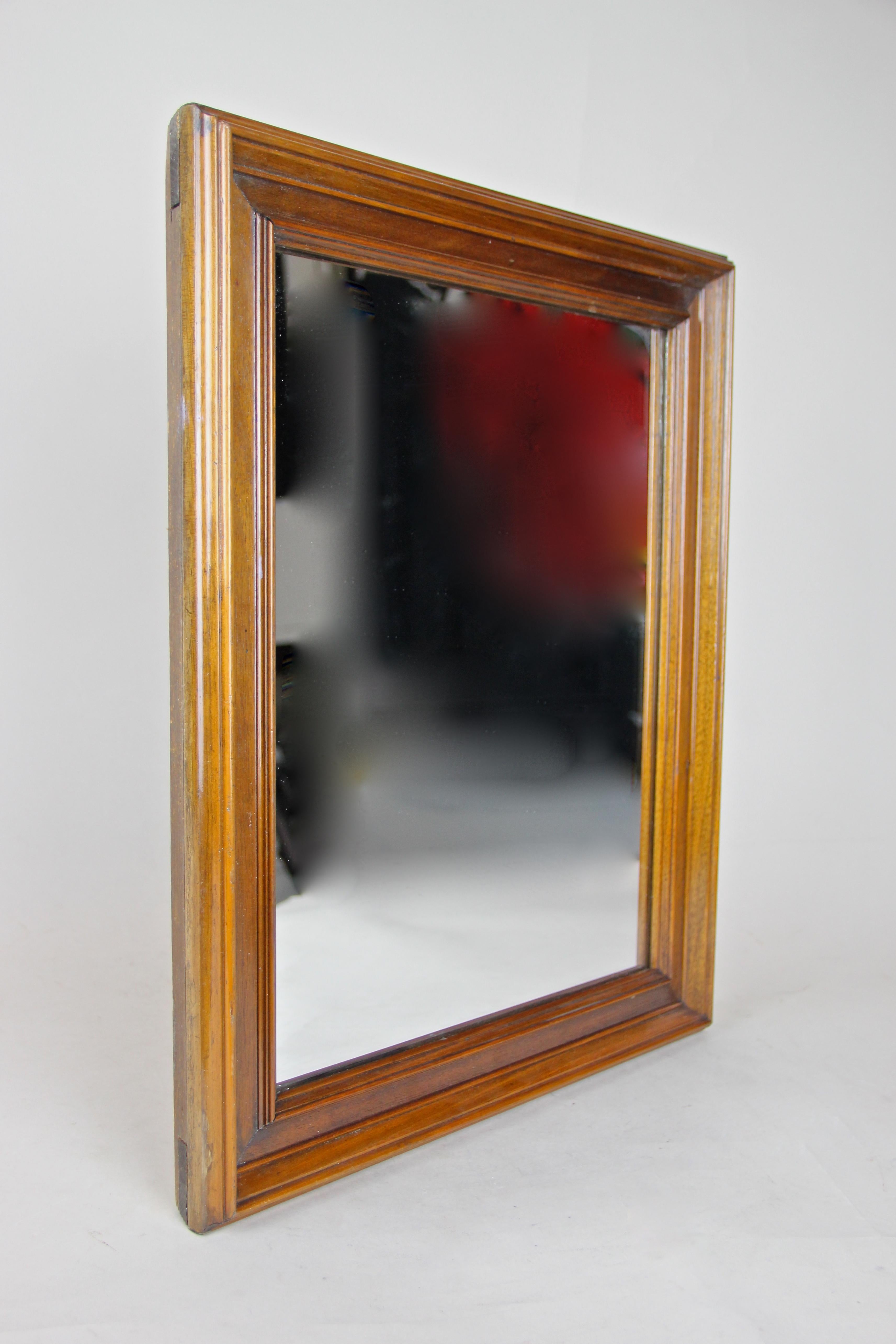 Beautiful Biedermeier Nutwood wall mirror out of Austria from circa 1860, the second period. This mid-sized 19th century wall mirror features great carved nut wood bars over an overlapped inserted substructure. The straight design alongside the