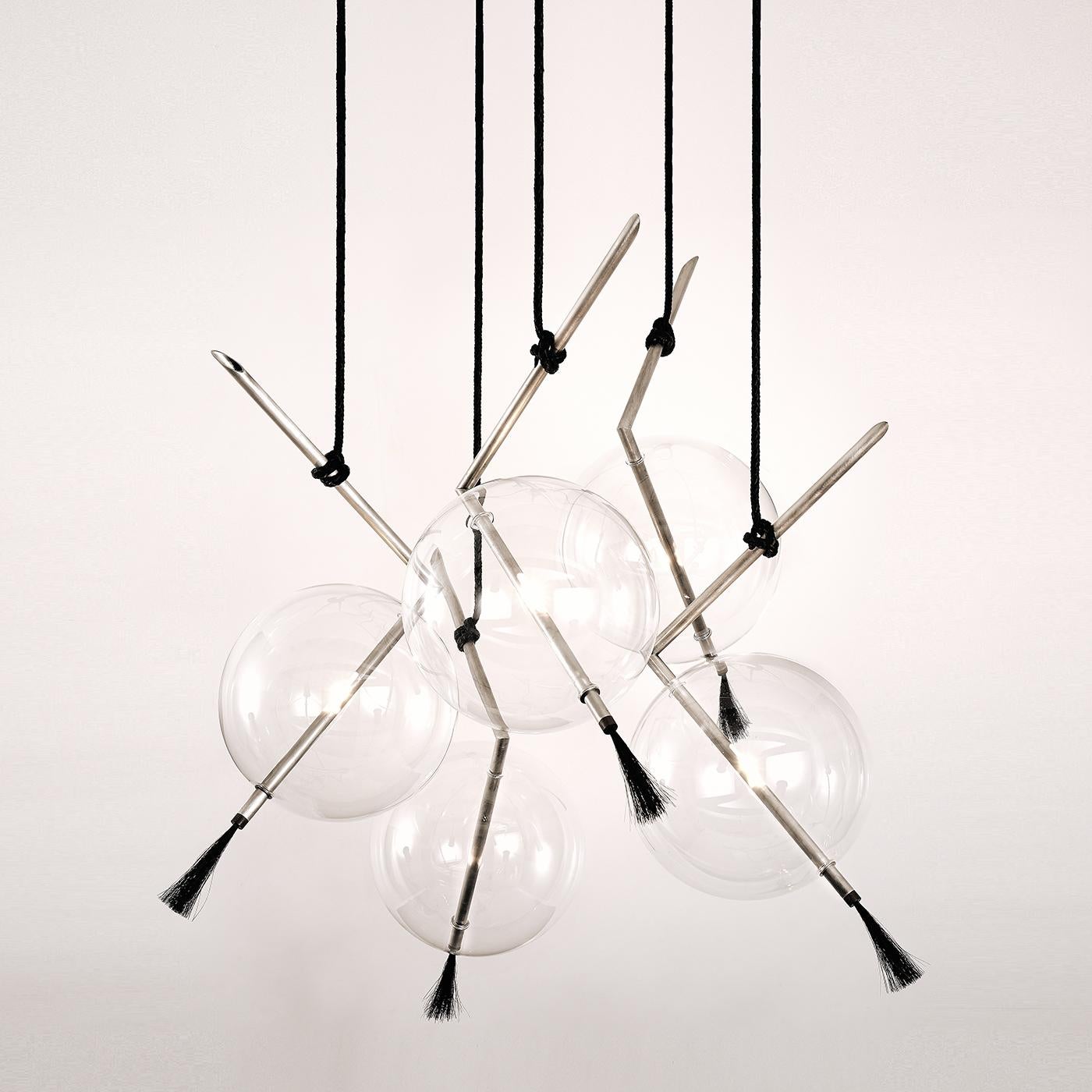 Un eclettico mix di materiali bilanciati in un design contemporaneo di grande impatto visivo, questo lampadario dell'esclusiva edizione in argento creerà un'atmosfera drammatica in qualsiasi interno. Cinque bracci a V in ottone spazzolato con
