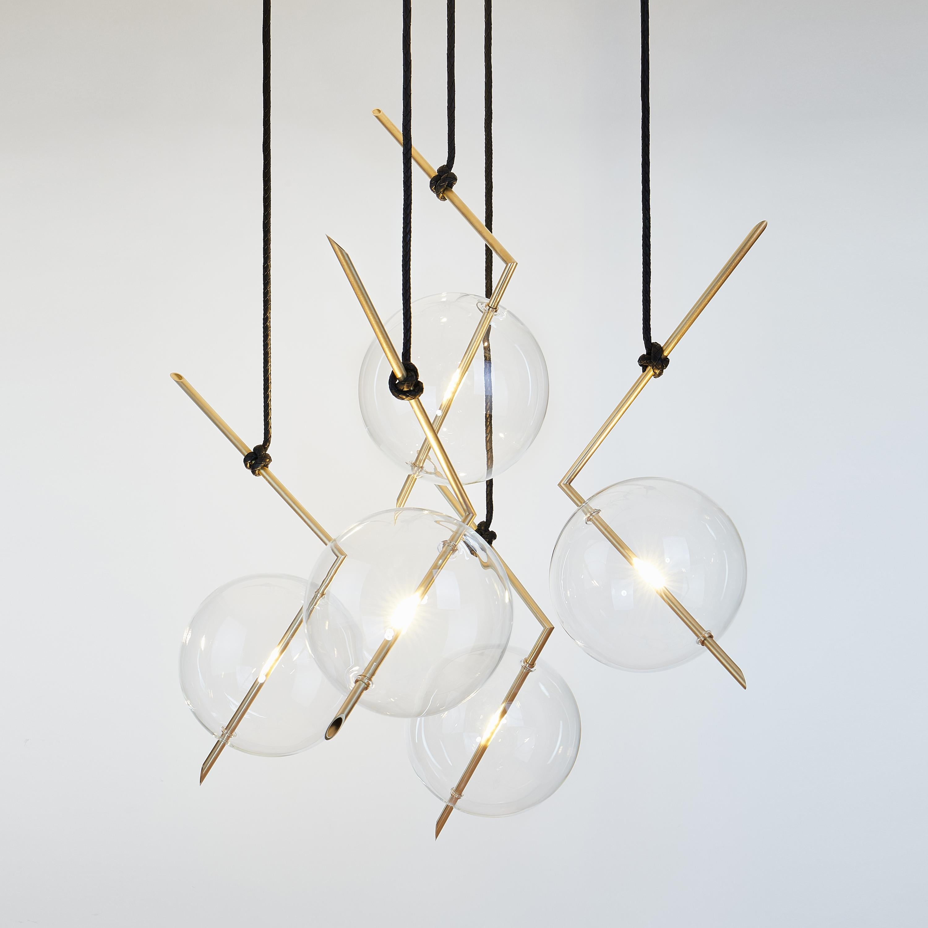 Nuvola five-light floats in space like a jewel hanging from the ceiling, hooked at the end of a leather cord that has been hand knotted around the brass tube; a perfect equilibrium of different materials, with obsessive attention to details.

The