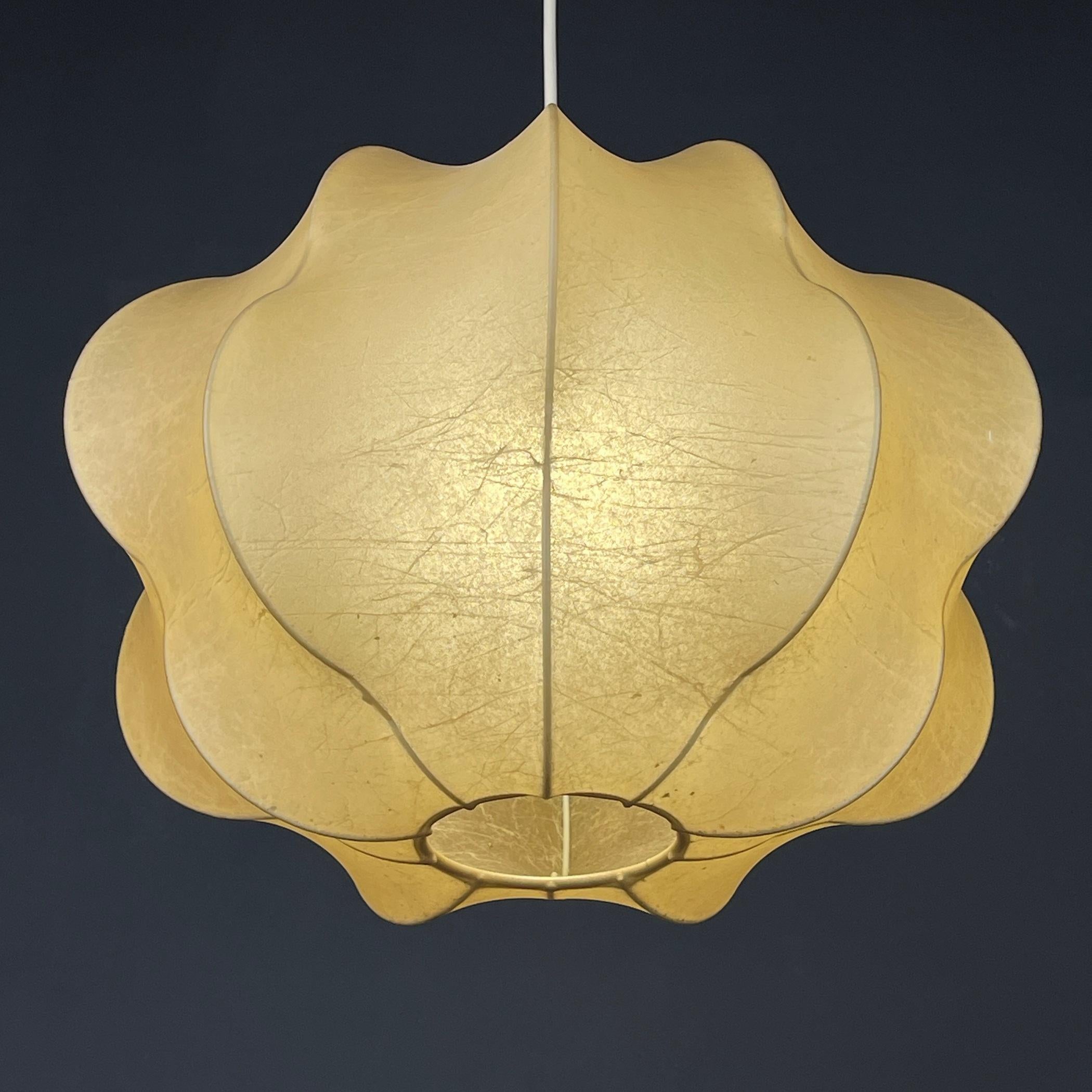 Step into the captivating world of Italian Mid-Century Modern design with the Nuvola cocoon chandelier by Tobia Scarpa for Flos in 1962. This light suspension model boasts an internal metal rod frame, gently embraced by a cocoon covering. Crafted by