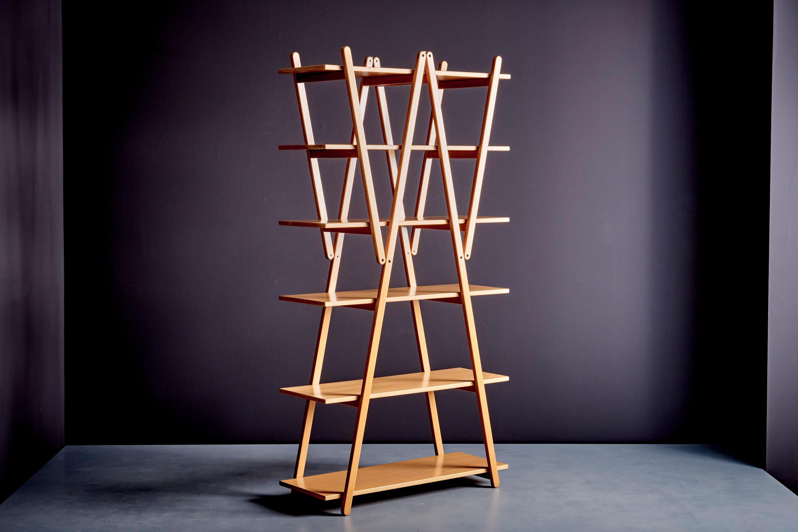Nuvola Rossa is a bookshelf designed by Vico Magistretti and produced by Cassina in 1977. This piece of furniture is characterized by a foldable structure composed of diagonal braces that serve as support for the shelves, making it not only a