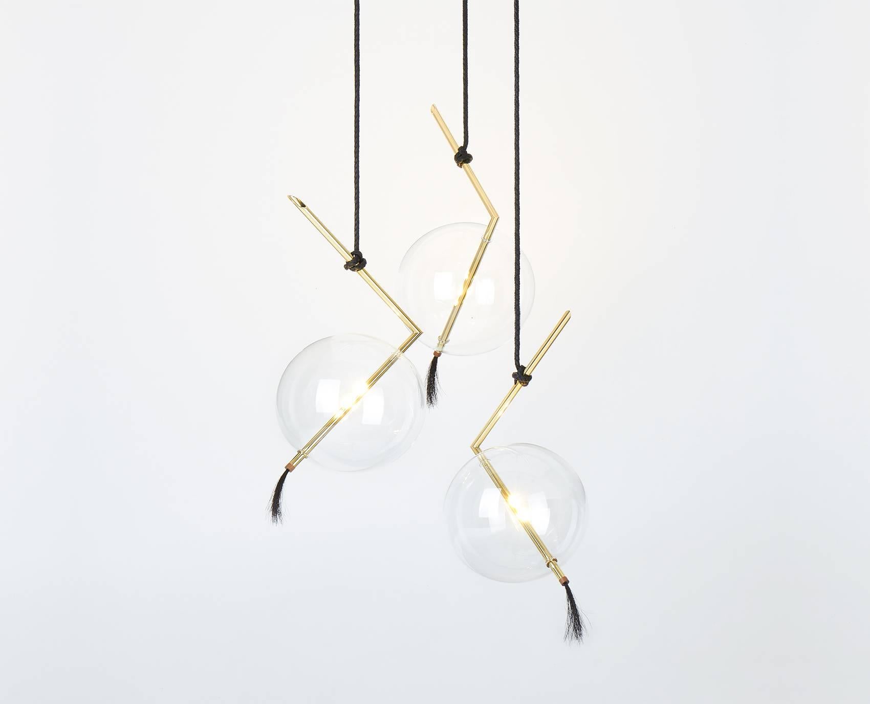 Nuvola Three Lights Customizable Chandelier or Pendant light-fixture floats in space like a Jewel hanging from the Ceiling.
The pure Geometry of the Brass Rod containing the led light contrasts with the ephemeral transparency of the Handblown