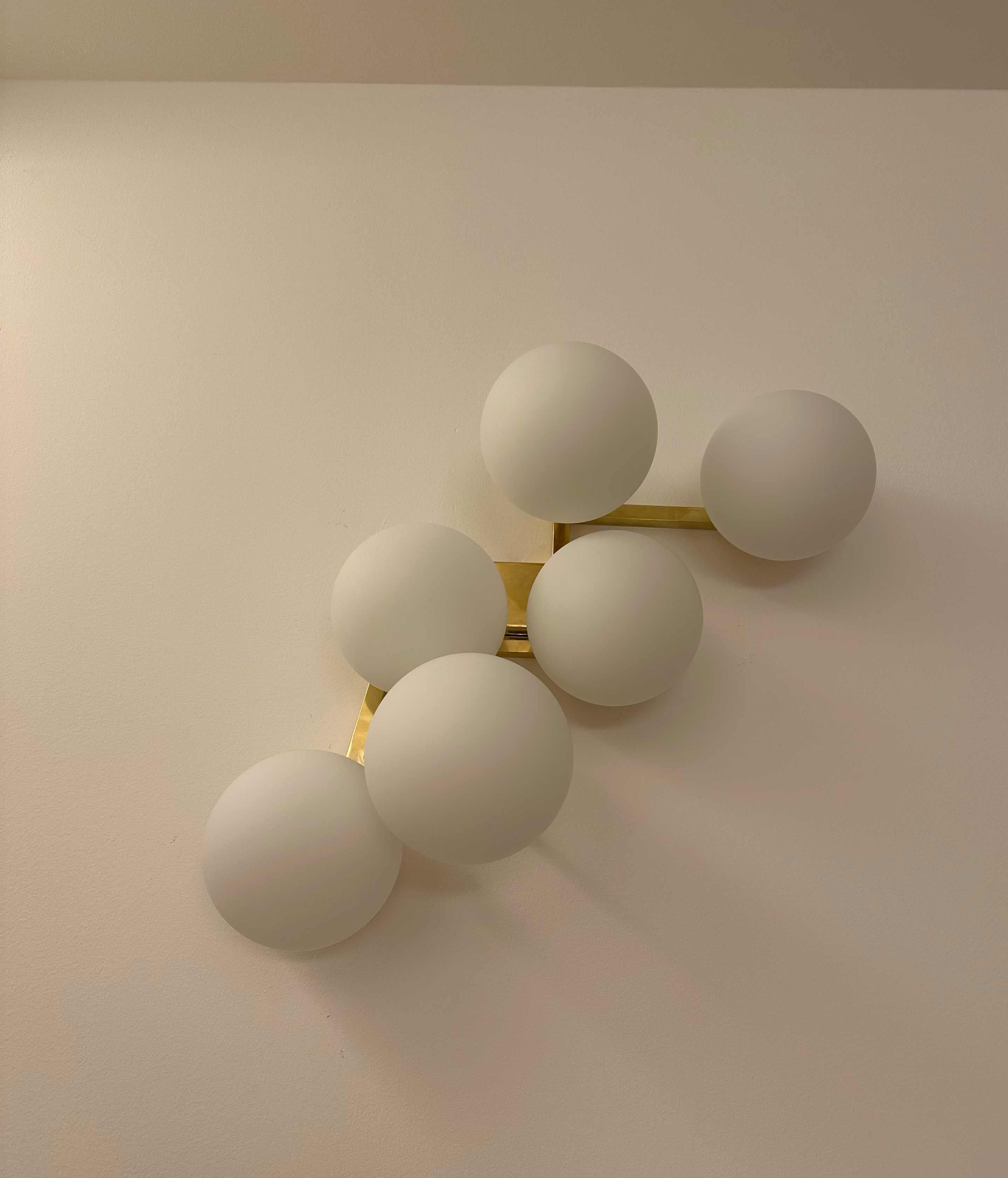 Elegantes apliques de pared con estructura de latón y 6 esferas de cristal de Murano. El diseño refinado y la artesanía de alta calidad de las esferas de cristal crean un ambiente luminoso y sofisticado, perfecto para realzar cualquier espacio. Una