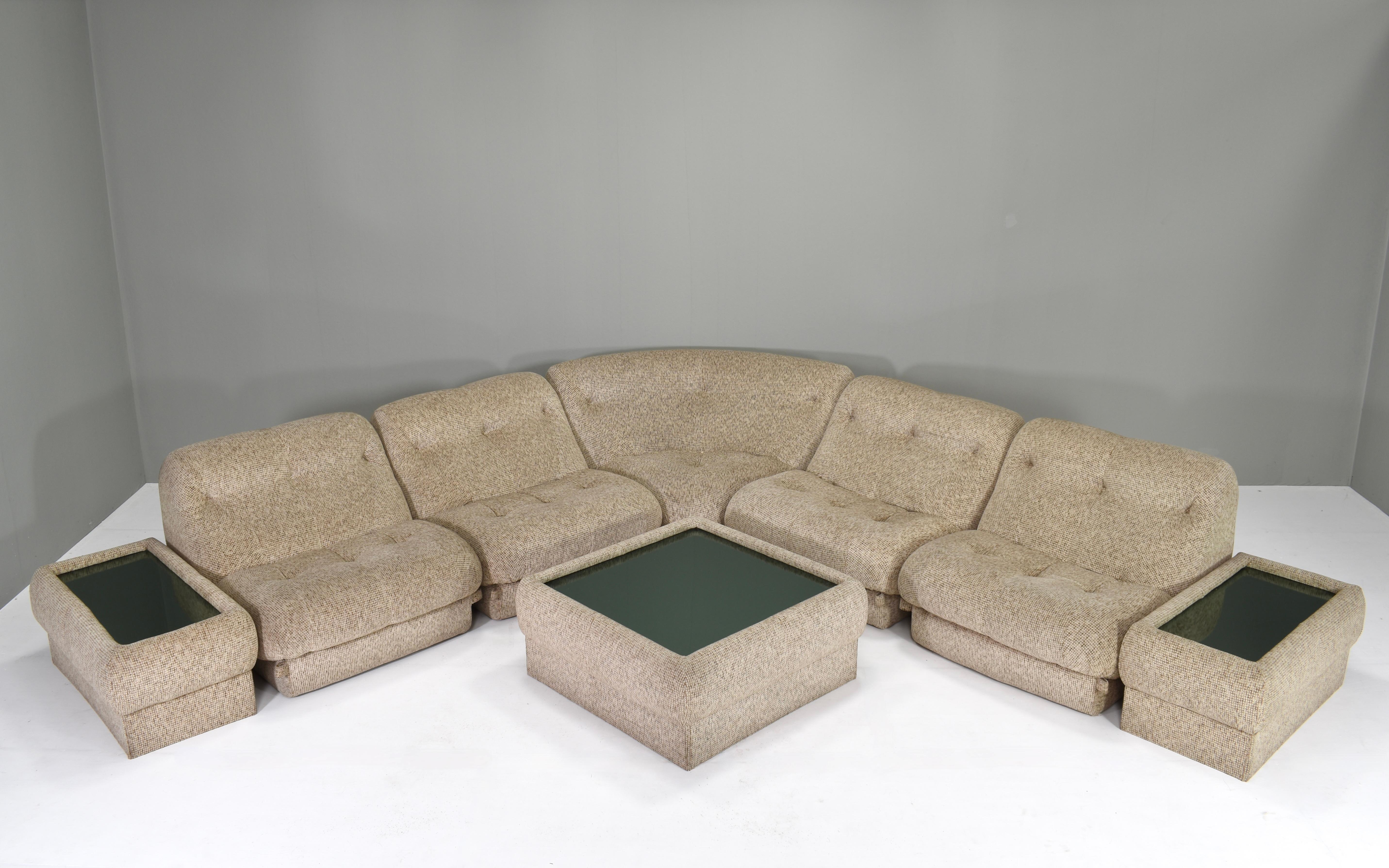 Nuvolone sectional sofa by Rino Maturi with three mirror glass coffee tables.
The sofa features 4 straight sections, 1 corner section and three coffee tables. The fabric is made of thick high-end beige/creme wool. The sofa is in very good condition