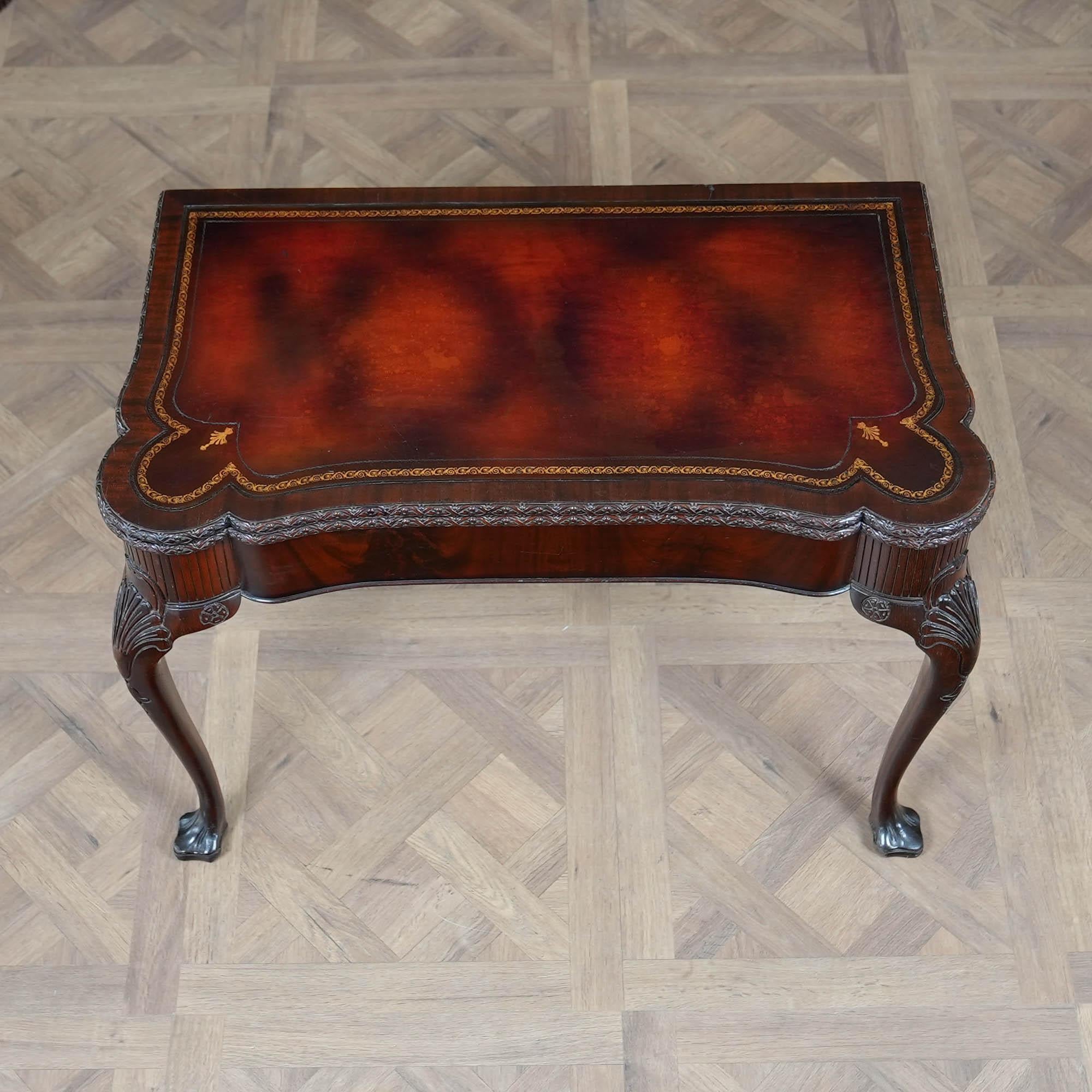 Table de jeu vintage à plateau en cuir, dotée d'un superbe plateau en cuir d'origine de grande qualité et d'un bandeau en acajou entourant le plateau. Conçue d'après un original antique, cette table de jeu vintage en acajou marqueté a été fabriquée