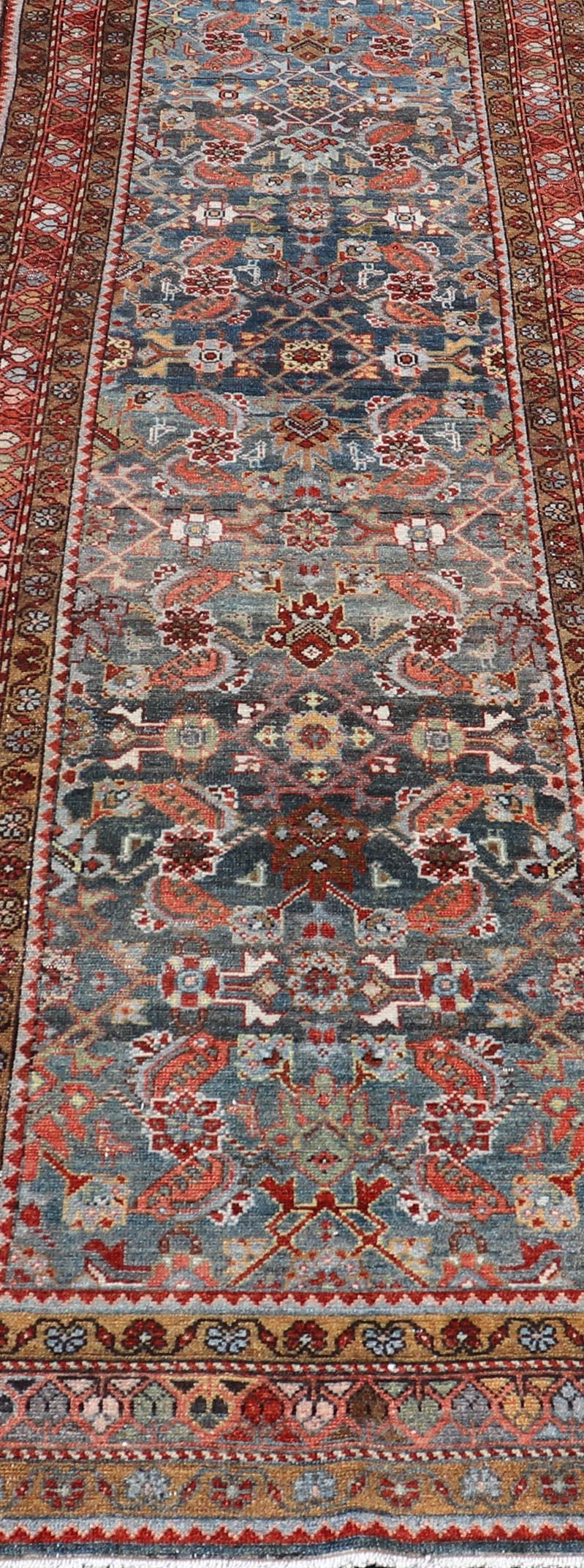Early 20th Century N.W. Persian Antique Runner with Geometric Florals Set on a Blue Field For Sale