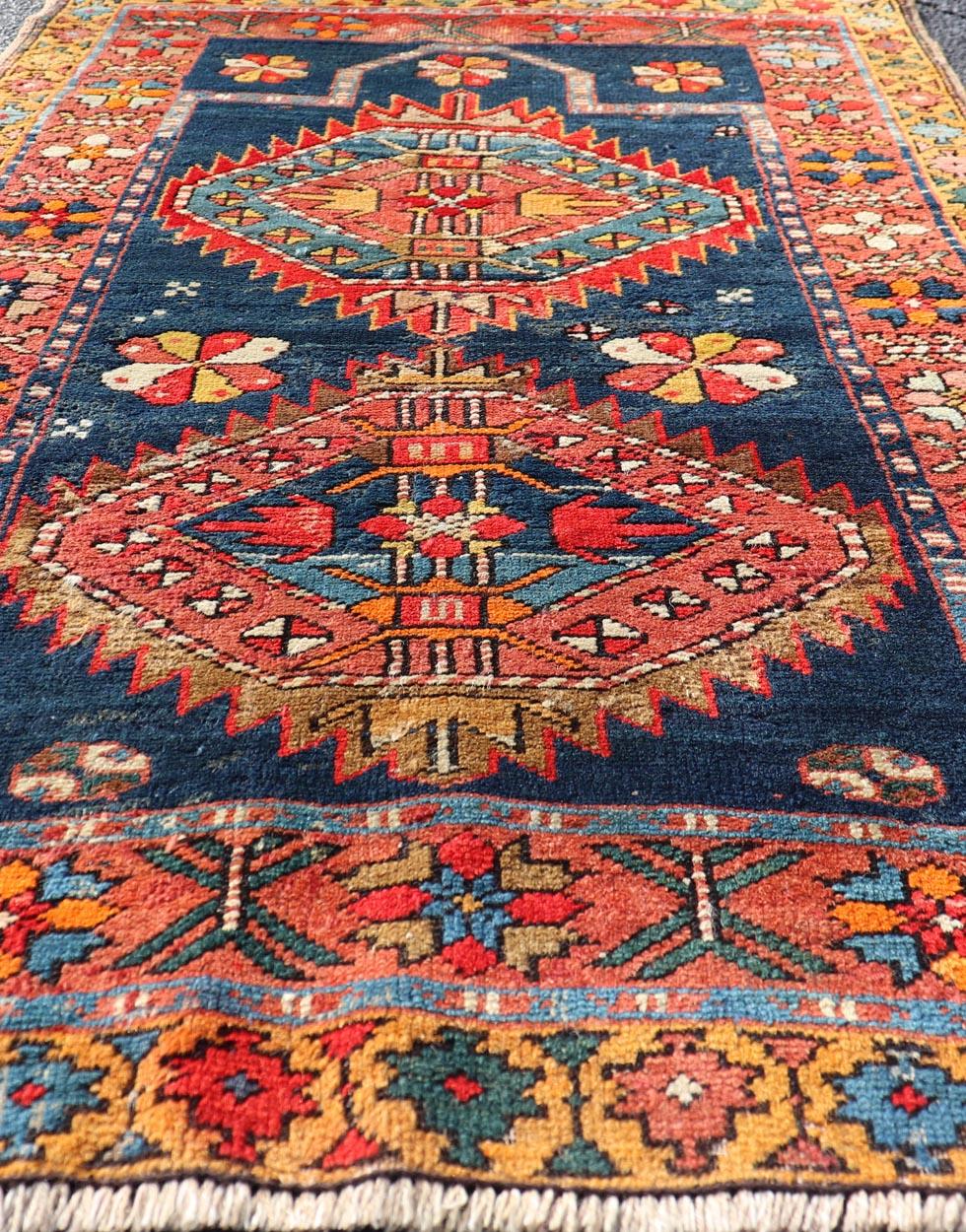 N.W. Tapis persan avec médaillon géométrique avec fleurs Keivan Woven Arts. 
Keivan Woven Arts / X23-1210-344, pays d'origine / type : Iran / N.W. Persan, vers 1900.
Mesures : 2'10 x 4'6 
L'élégant motif en médaillon dans le champ consiste en un