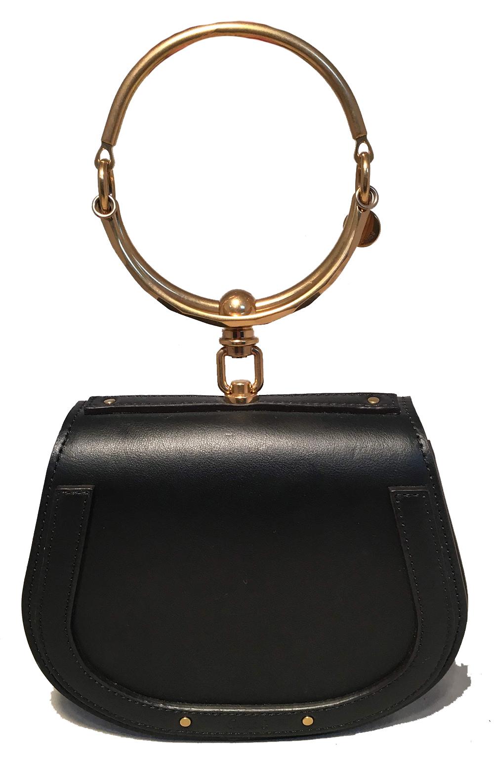 NWOT Chloe Nile Small Black Leather Bracelet Bag in unused condition. Black smooth leather exterior trimmed with matte gold hardware. Unique hoop bracelet top handle. Back side slit pocket. Front flap snap closure opens to a suede interior that