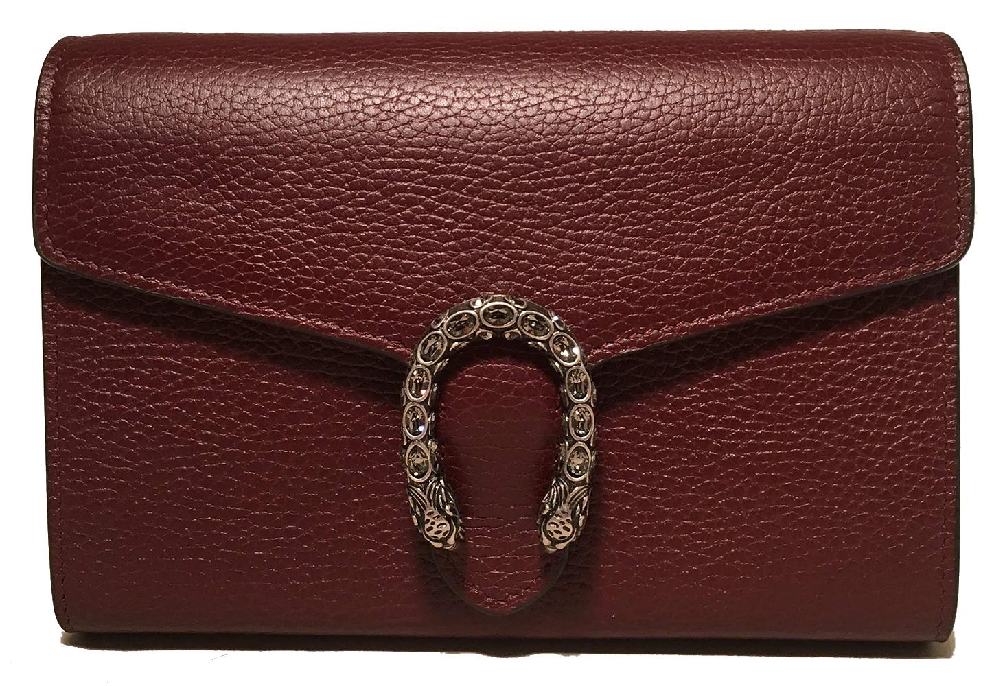 NWOT Gucci Dionysus Maroon Pebbled Leather Mini Chain Serpent Wallet Clutch Bag in like new condition. Maroon pebbled leather exterior trimmed with antiqued silver hardware and an rhinestone embellished snake upon the front flap. Snap flap closure