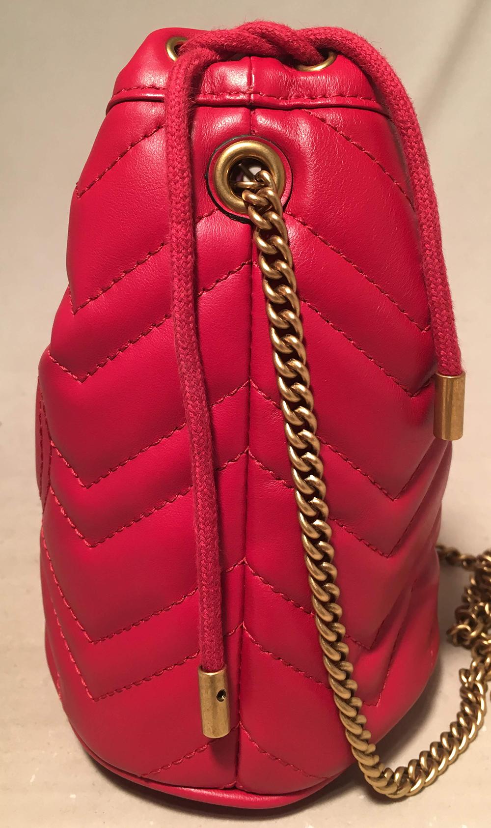 Gucci GG Marmont Mini Quilted Red Leather Bucket Bag in NWOT condition. Red chevron quilted leather exterior trimmed with bronze hardware. Signature bronze GG gucci logo along front side and adorable quilted heart along back. Removable bronze chain