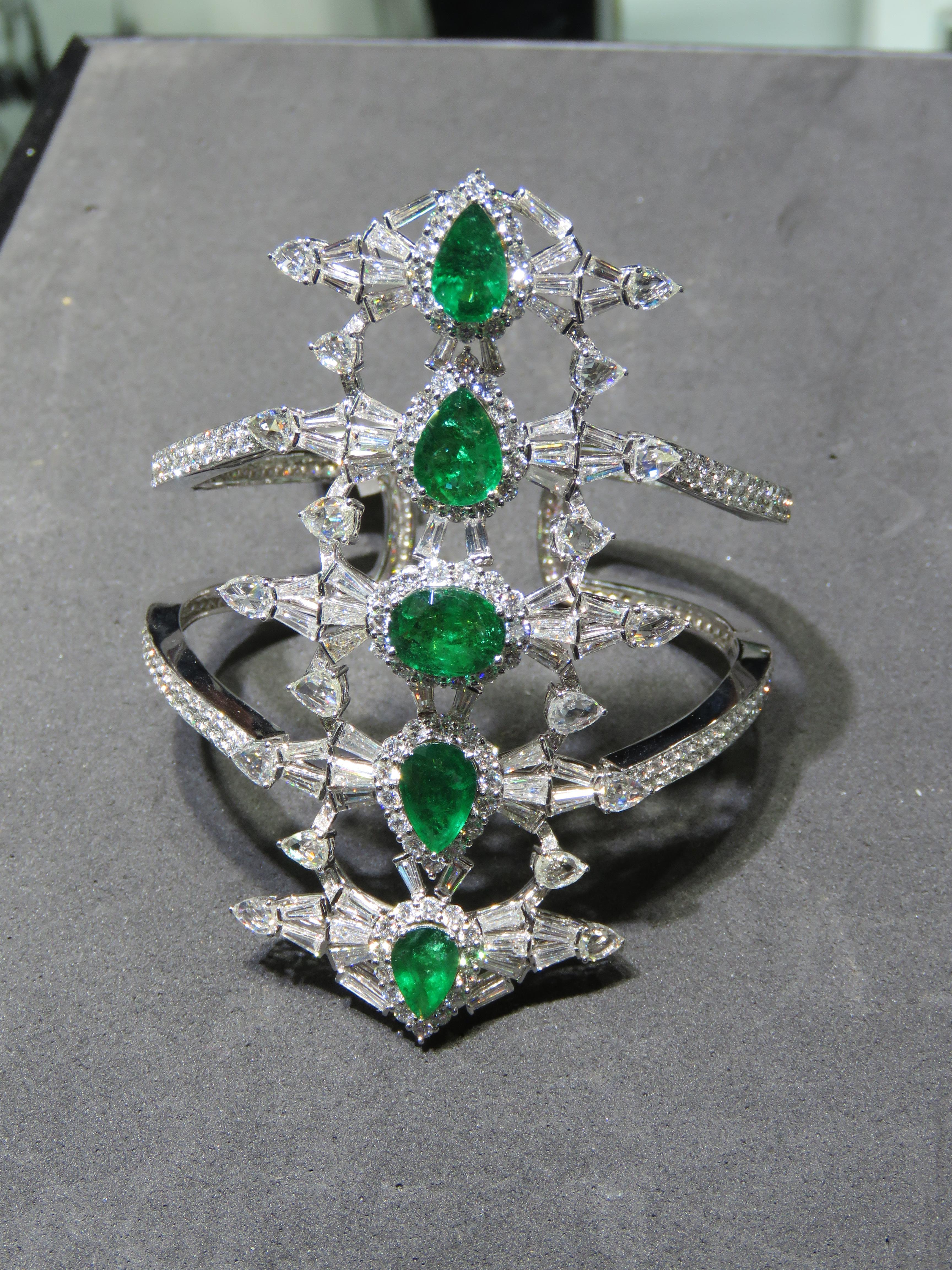 A Rare 18KT White Gold Emerald Diamond Bangle Bracelet. Bangle is comprised of Finely Set Glittering Gorgeous Emeralds and adorned with Sparkling Fancy Shaped Rose Cut Diamonds and White Diamonds and Pear Shaped and Oval Emeralds!! T.C.W. approx