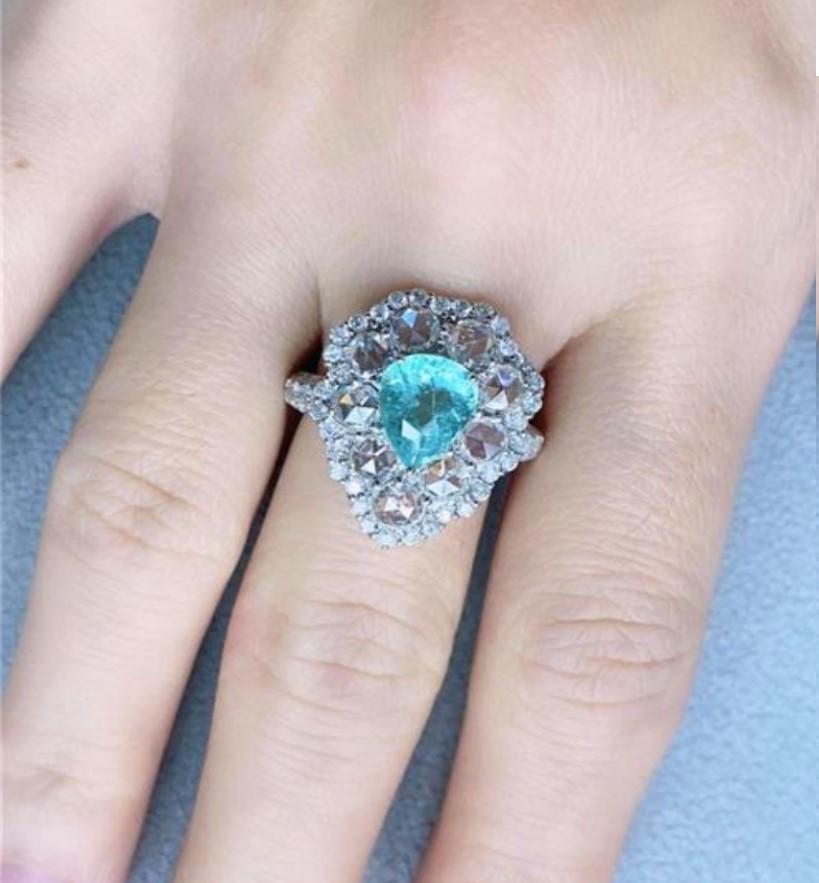 Il seguente oggetto è uno splendido anello in oro bianco 18KT stile Winston con tormalina Paraiba RARE ROSE CUT Diamond!!!! L'anello presenta un'eccezionale tormalina Paraiba di grandi dimensioni, dal taglio raro e scintillante, a forma di pera,