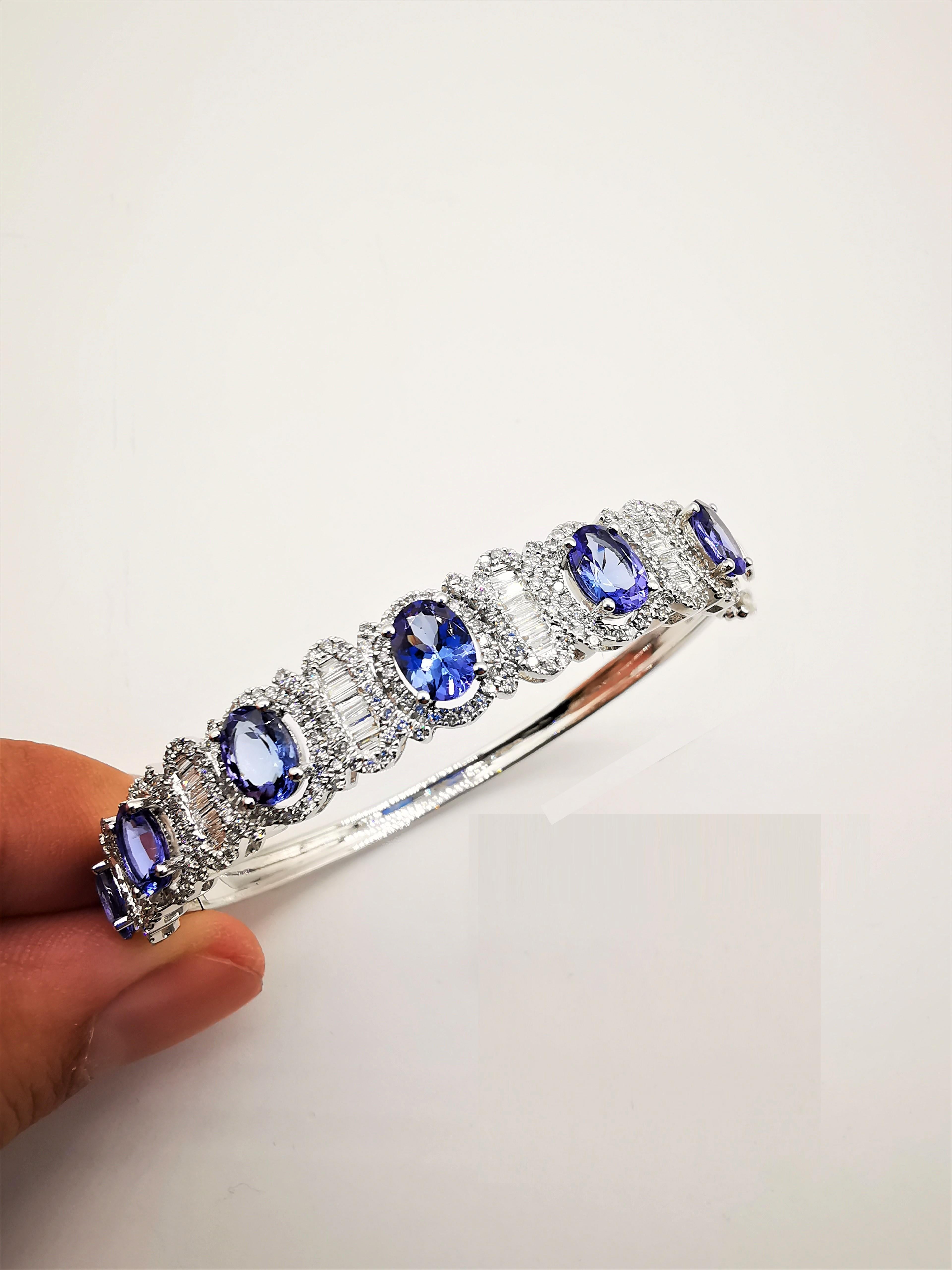 The Following Item we are offering is a Rare Important Radiant 18KT Gold Large Magnificent Rare Fancy Gorgeous Fancy Tanzanite and Diamond Bangle Bracelet. Bangle is comprised of Exquisite Fancy Oval Cut Intense Rich Tanzanites connected with