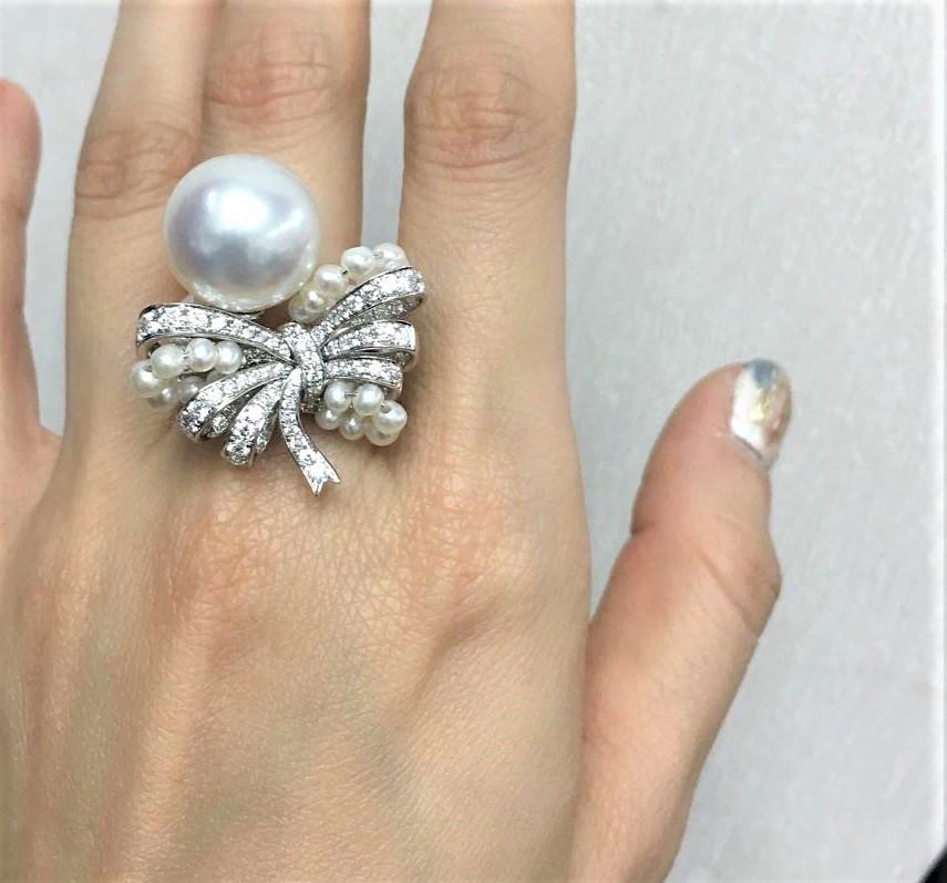 The Following Item we are offering is this Extremely Rare Beautiful 18KT Gold Fine Rare Fancy Large South Sea Pearl Fancy Diamond Bow Ring. This Magnificent Ring is comprised of Rare a Fine Large 13-14MM Fancy South Sea Pearl surrounded with Round