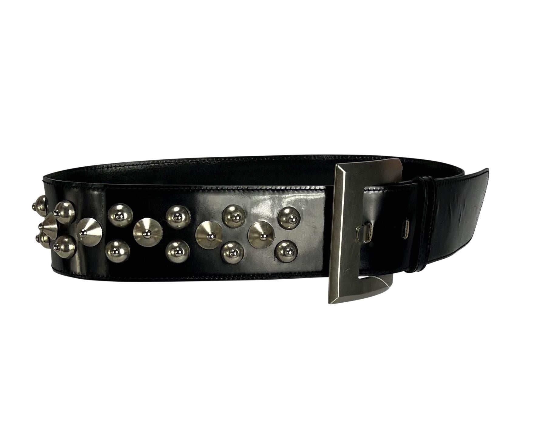 Presenting a fabulous black patent leather Gianni Versace belt, designed by Gianni Versace. From the late 1980s, this wide belt is made complete with a large angular silver-tone buckle and studs along the strap. Never worn before, this incredible