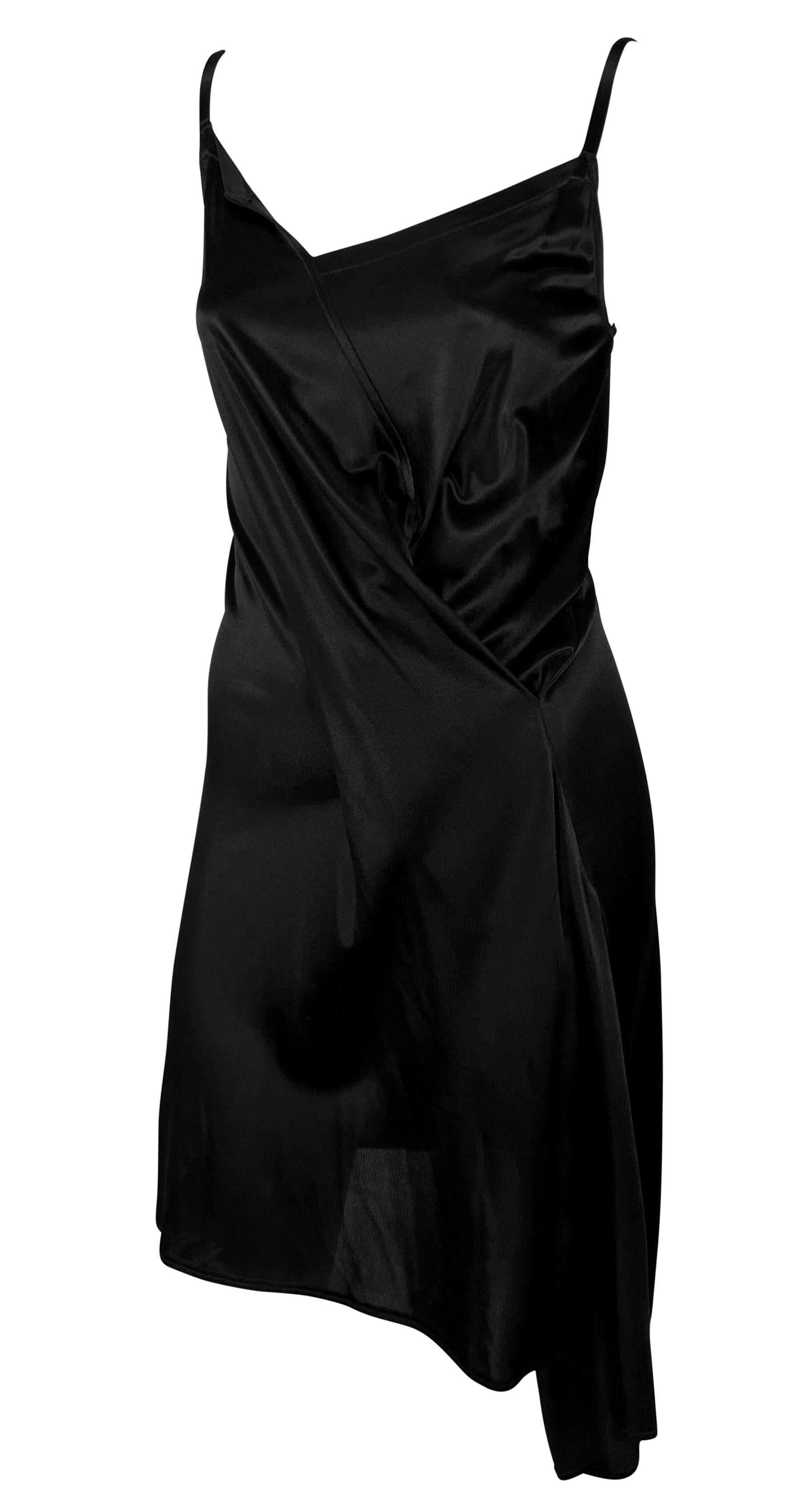 Dieses asymmetrische Wickelkleid wurde in den 1990er Jahren von Ann Demeulemeester entworfen und zeichnet sich durch einen eckigen Ausschnitt, leichte Raffungen an der Taille und einen asymmetrischen Saum aus. Dieses Vintage-Minikleid ist komplett