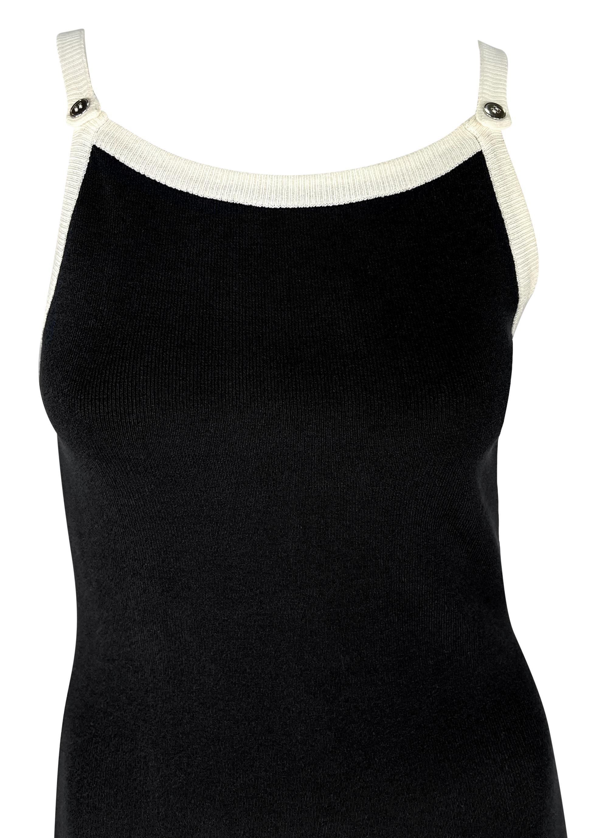 Este minivestido Dolce & Gabbana de los años 90, de punto blanco y negro y nuevo con etiquetas, está diseñado en estilo slip y adornado con detalles de botones plateados con el logotipo a lo largo de los tirantes. El vestido presenta una silueta