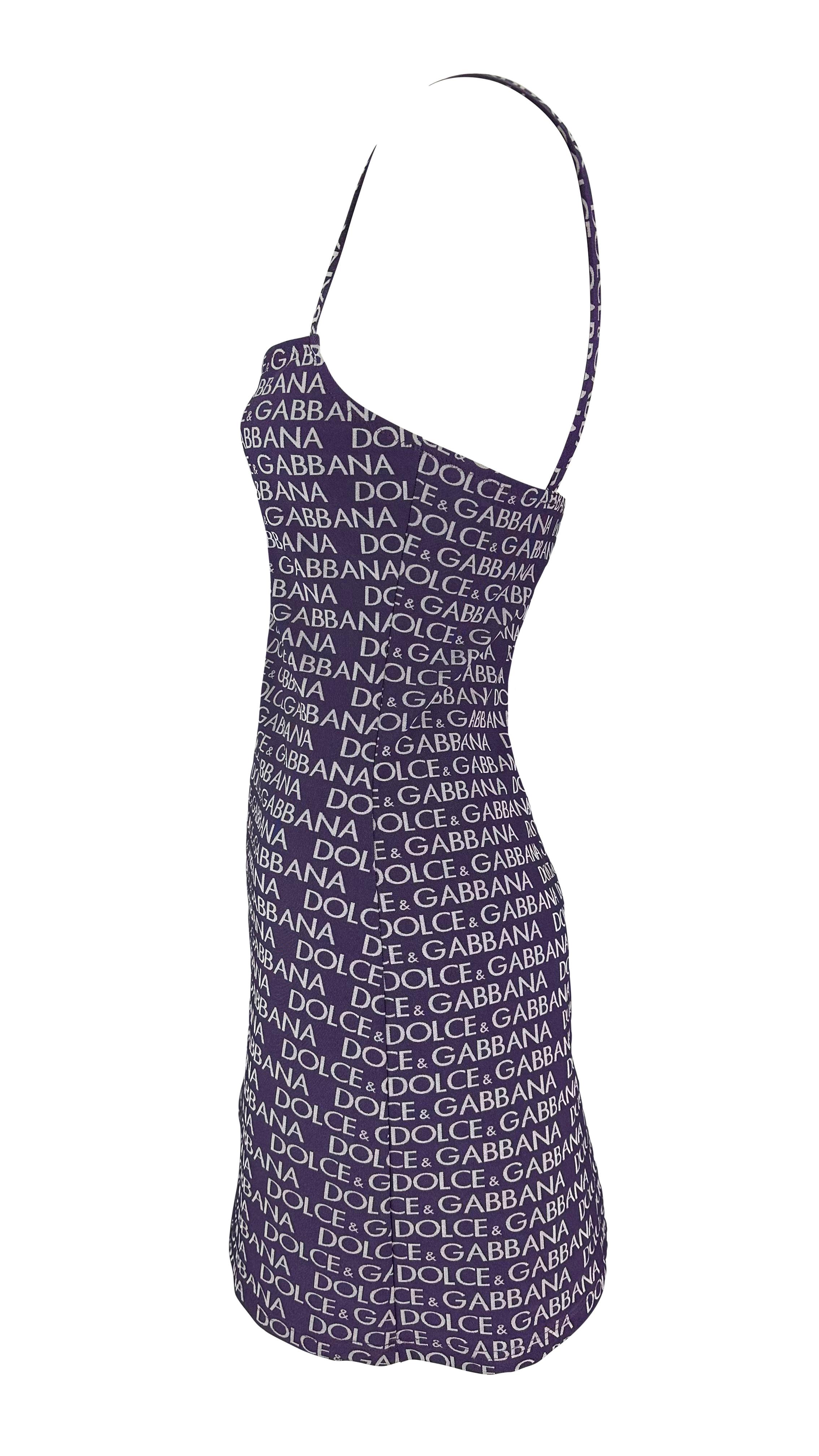 From the 1990s, this purple logo-branded Dolce & Gabbana mini dress is covered shoulder to hem in a 'Dolce & Gabbana' print. This mini beach dress features a slip-style, square neckline, and is complete with the original tags still attached.