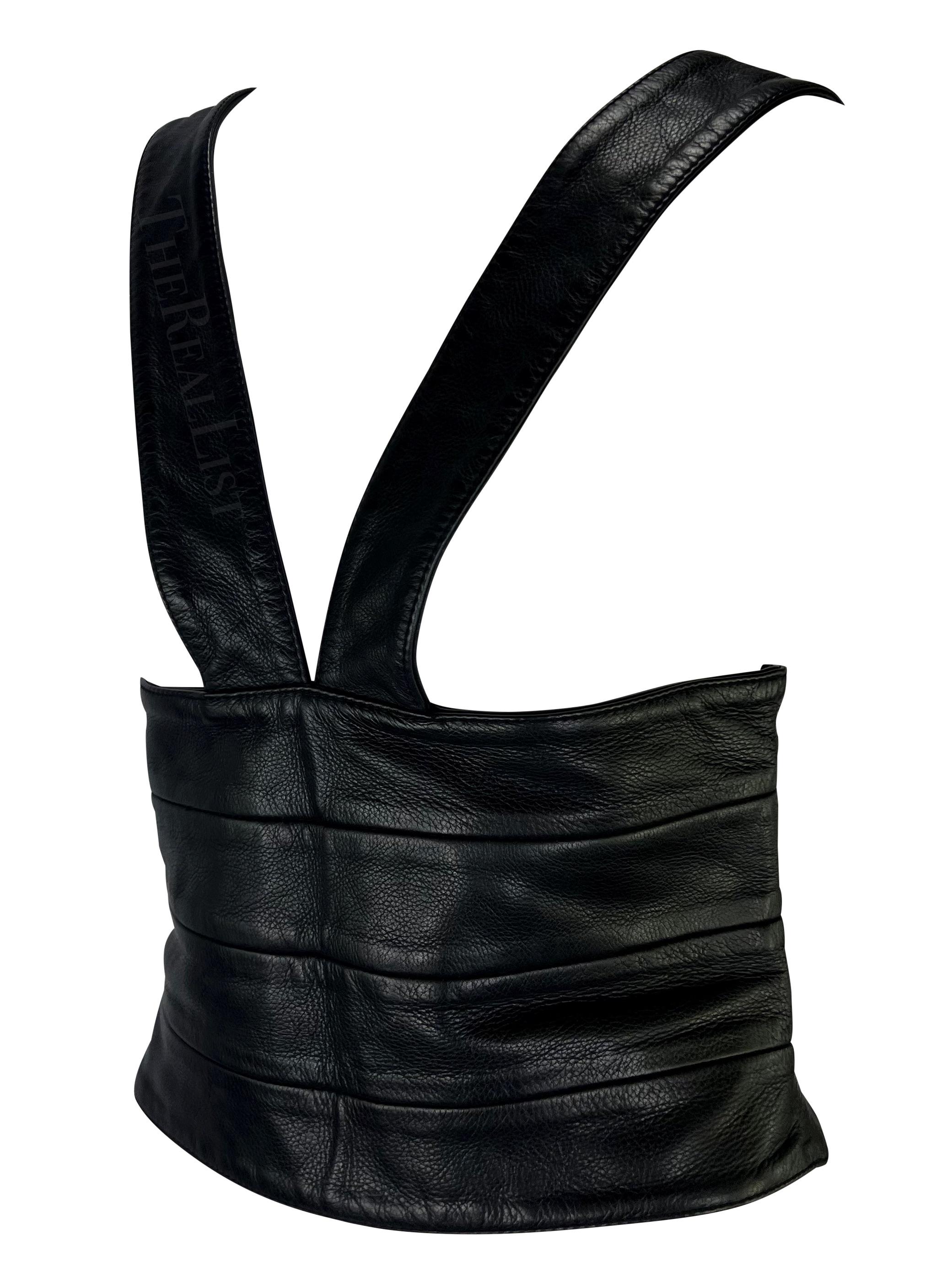 TheRealList presents: a black leather Givenchy cummerbund-style top. From the late 2000s, this men's top is constructed entirely of leather. The top features horizontal leather panels that wrap around the waist, a deep v-neckline, and straps that