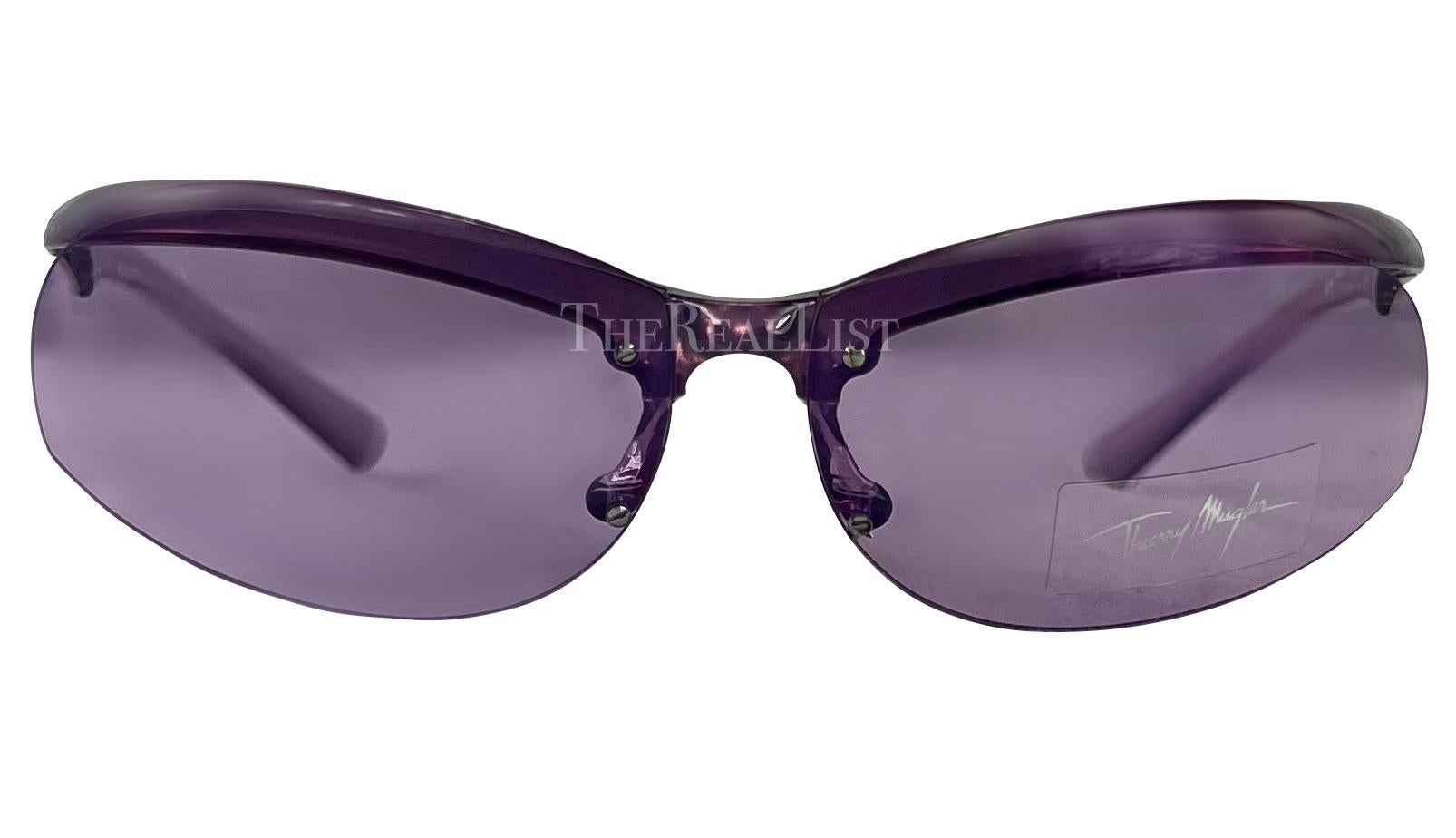 Presenting a pair of incredible purple Thierry Mugler sunglasses, designed by Manfred Mugler. From the early 2000s, these sporty biker-style sunglasses feature purple transparent arms and oval lenses. Never worn before, these sunglasses are made