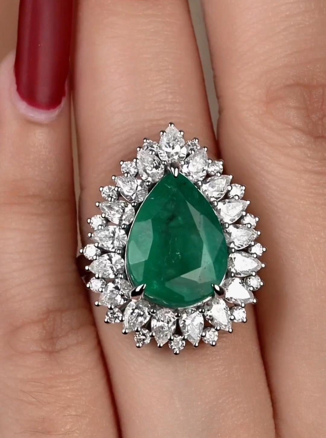 The Following Item we are offering is a Rare Important Radiant 18KT Gold Large Fancy Glittering Emerald and Diamond Ring. Ring is comprised of A LARGE Gorgeous Pear Shaped Fancy Emerald sitting atop Beautiful Glittering Fancy Glittering Round and