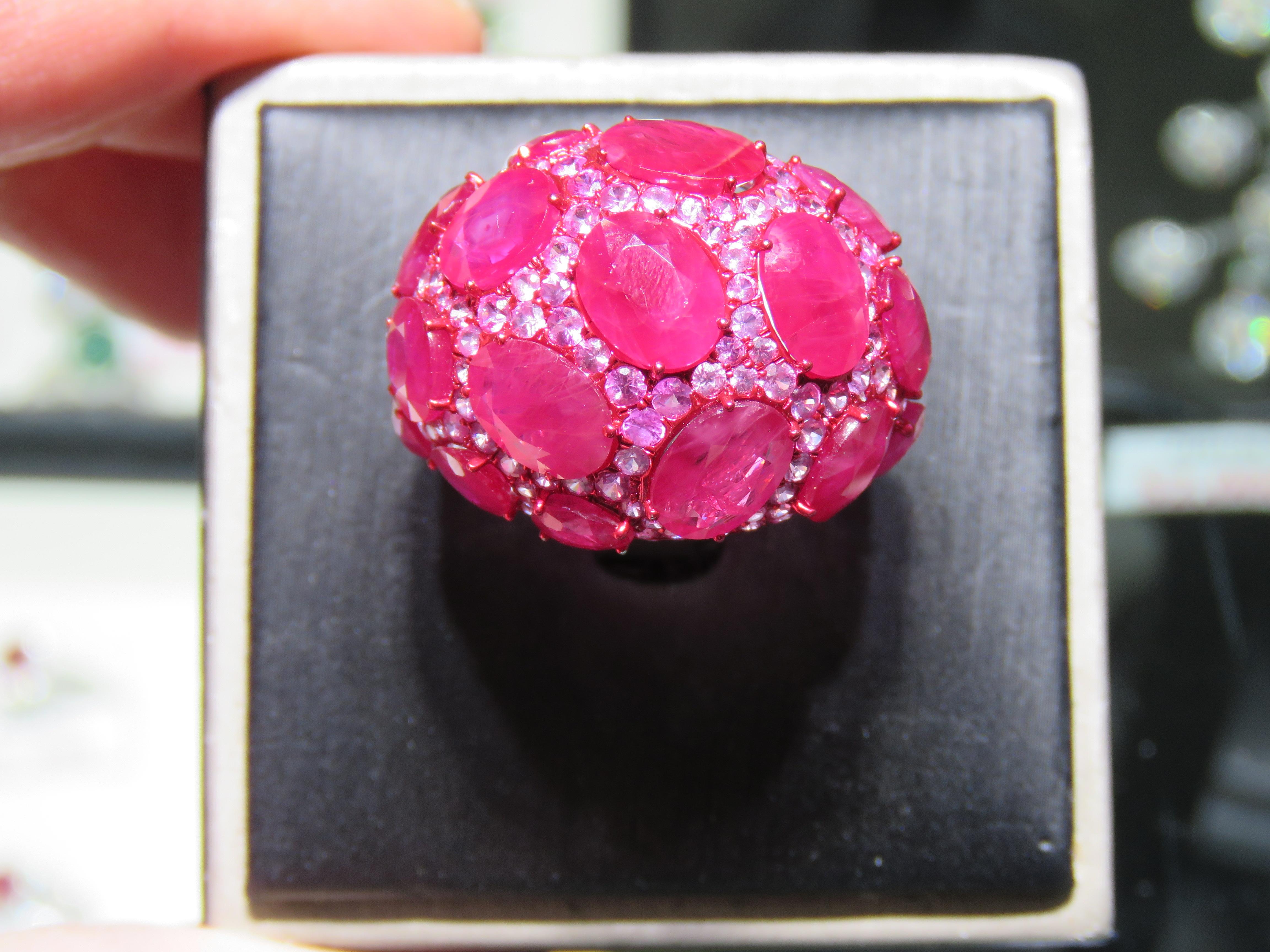 The Following Item we are offering is this Rare Important Radiant 18KT Gold Gorgeous Glittering and Sparkling Fancy Ruby, Pink Sapphire, and Diamond Ring. Ring Contains approx 23CTS of Beautiful Fancy Rubies framed with Pink Sapphires and Glittering