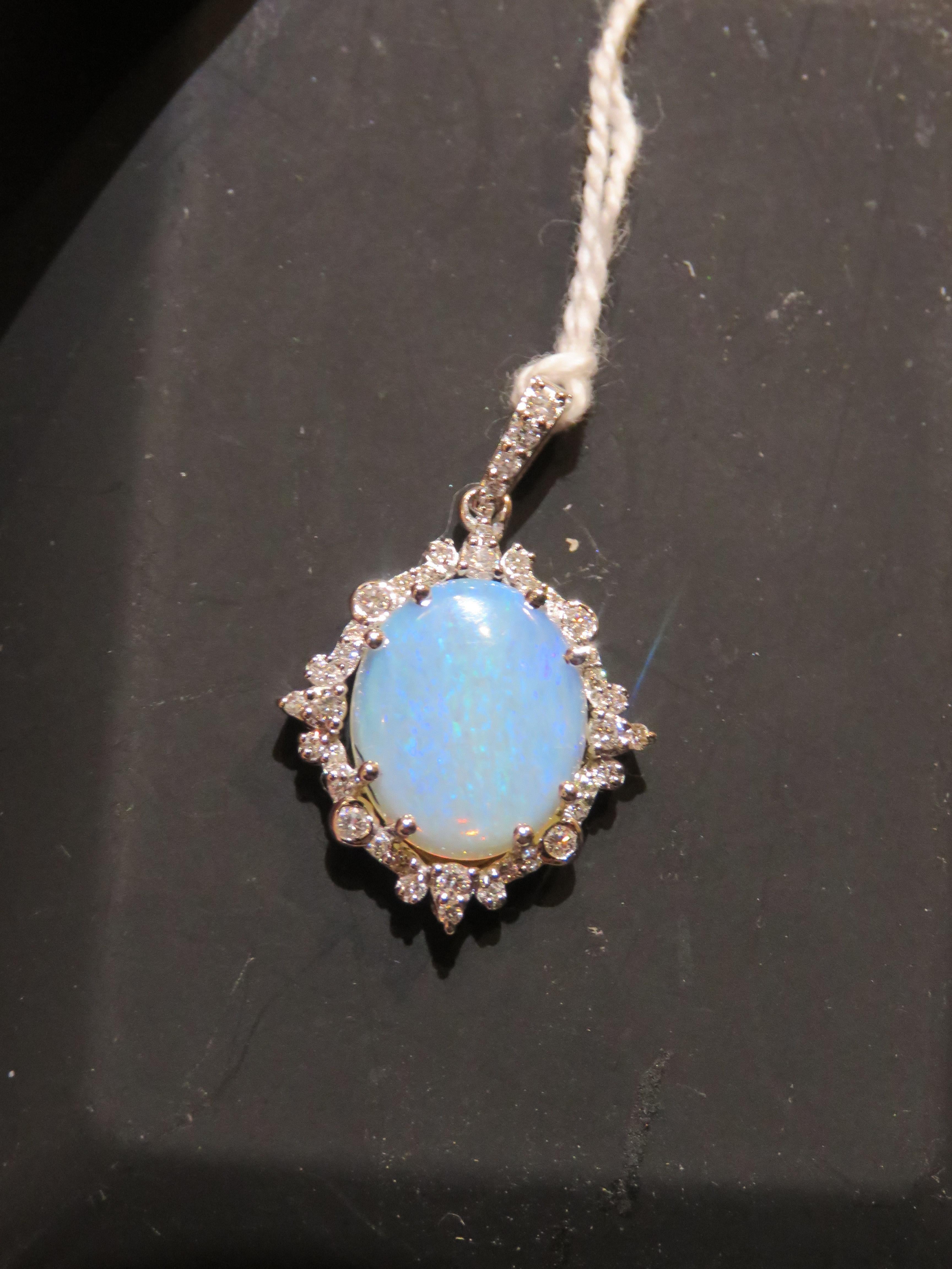 The Following Item we are offering is a Rare Important Radiant 18KT Gold Large Fancy Fiery Neon Blue Opal Diamond Pendant. Pendant is comprised of A LARGE Gorgeous Fancy 2.52CT Ethiopian Opal giving off hues of Neon Blue and Green surrounded by