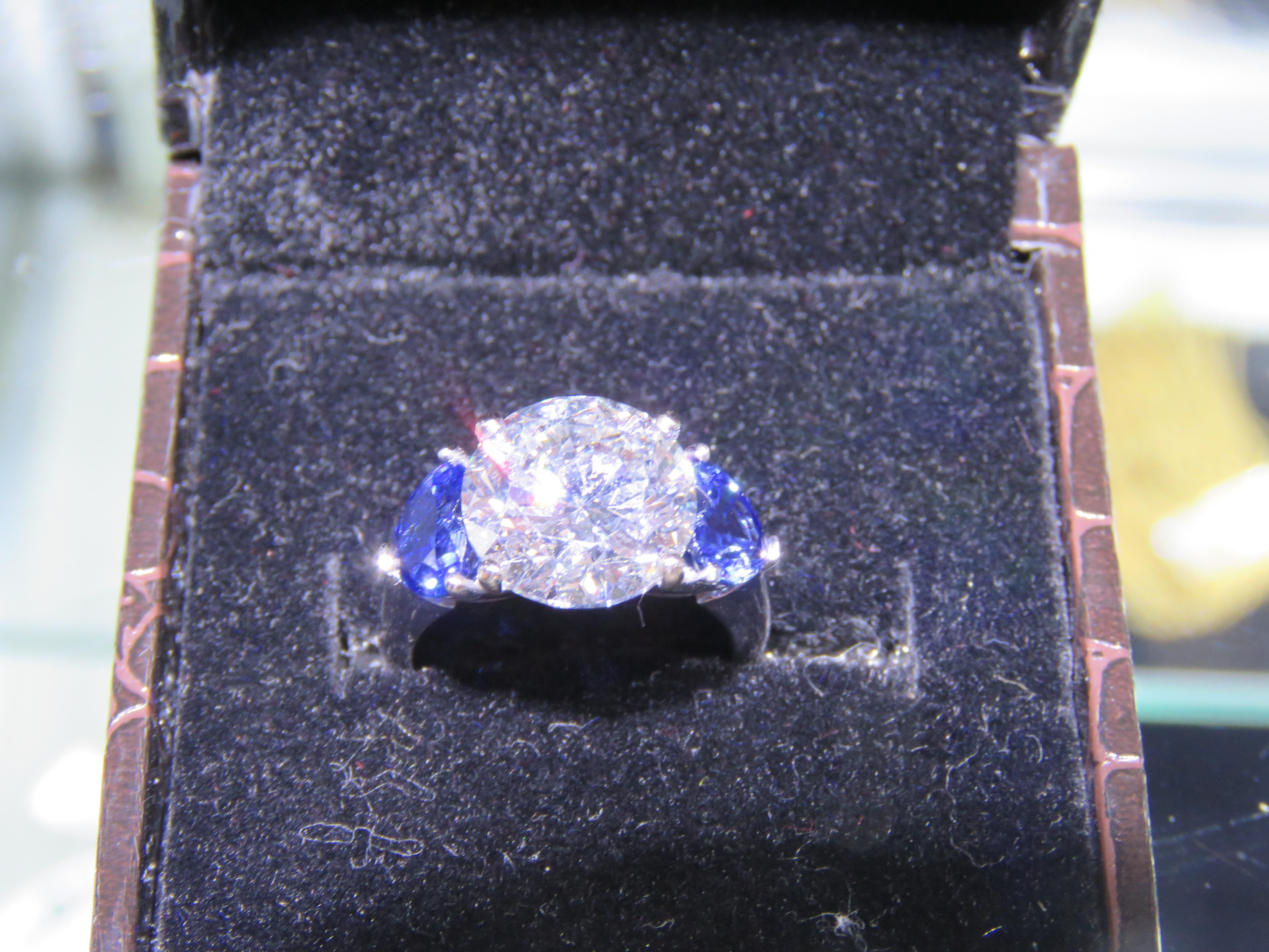 The Following Item we are offering is this Beautiful Rare Important Platinum Large Glittering Fancy Large Diamond Ring. Ring is comprised of a Large GIA Certified 5.01 F Color VVS2 Diamond adorned with 2 Rare Natural Blue Sapphire Hearts each