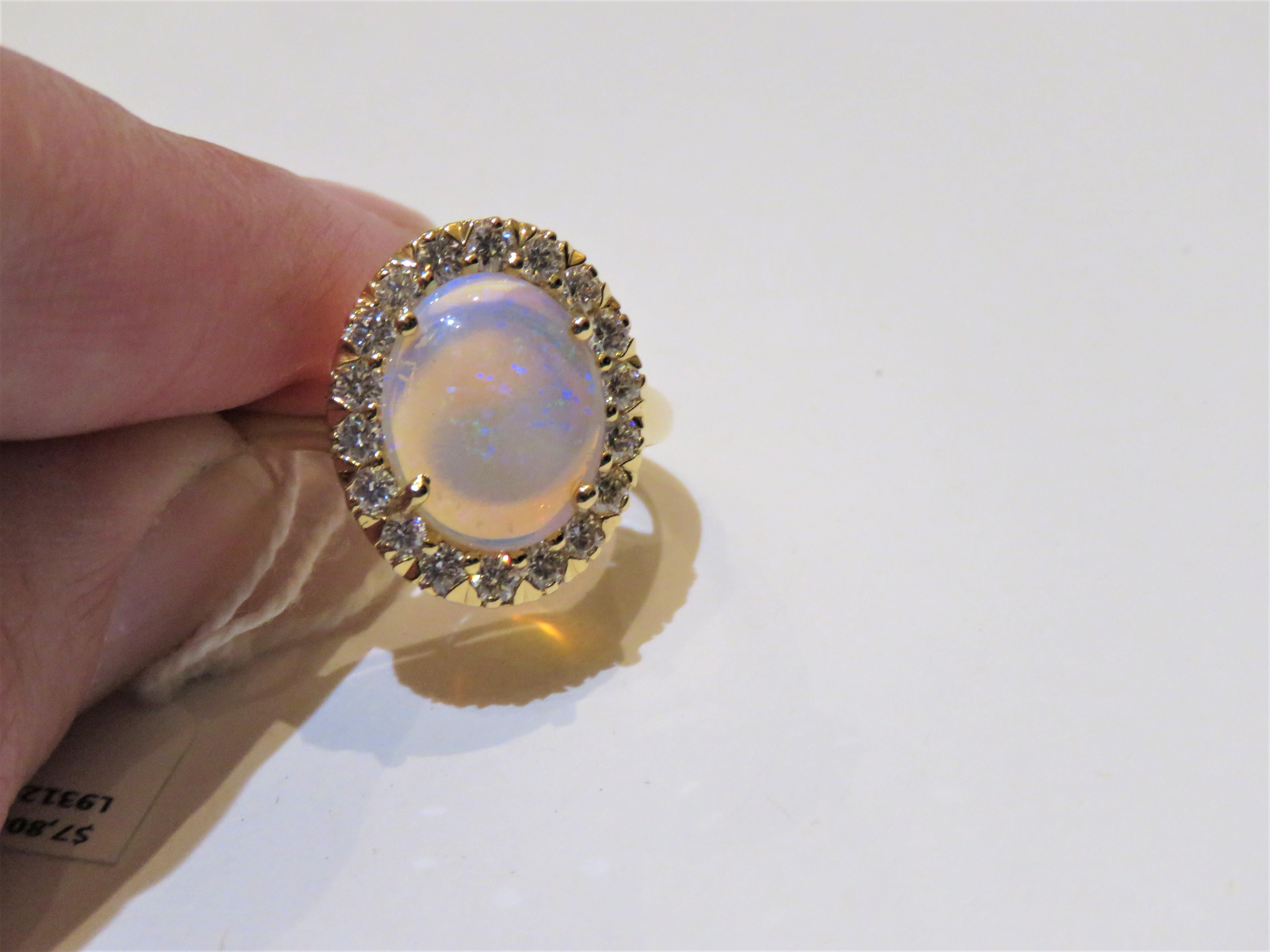 Das folgende Element, das wir anbieten, ist eine seltene wichtige Radiant 18KT Gold Large Fancy Fiery White Opal Diamond Ring. Der Ring besteht aus einem LARGE Gorgeous Fancy White Ethiopian Opal, umgeben von einem schönen Fancy umgeben Halo von