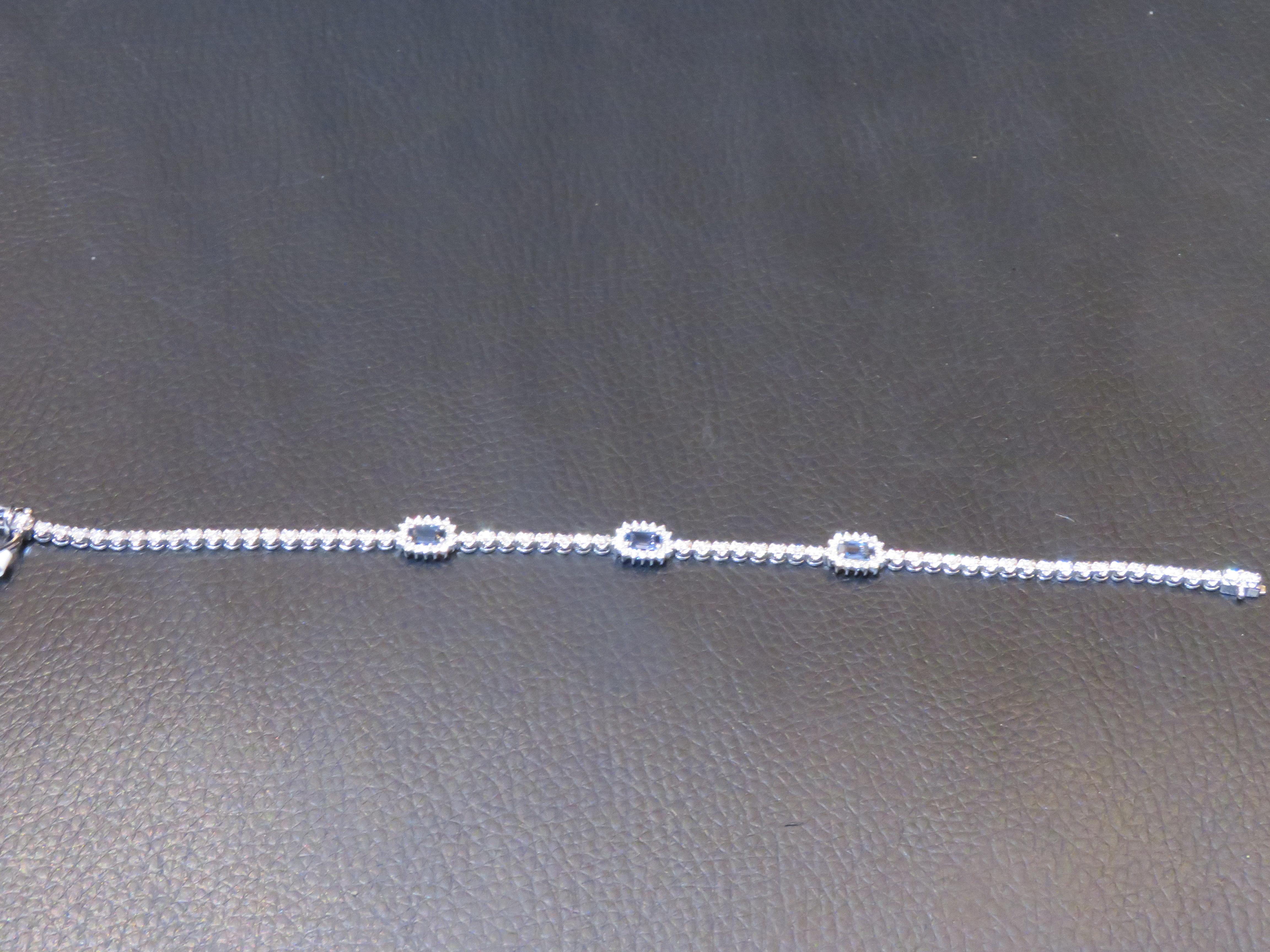 The Following Item we are offering is a Rare 18KT Gold Blue Sapphire and Diamond Tennis Bracelet. Bracelet is comprised of Finely Set 3 Gorgeous Glittering Emerald Cut Sapphires Framed and intertwined Magnificent Diamonds!!! T.C.W. Approx 2CTS!! The