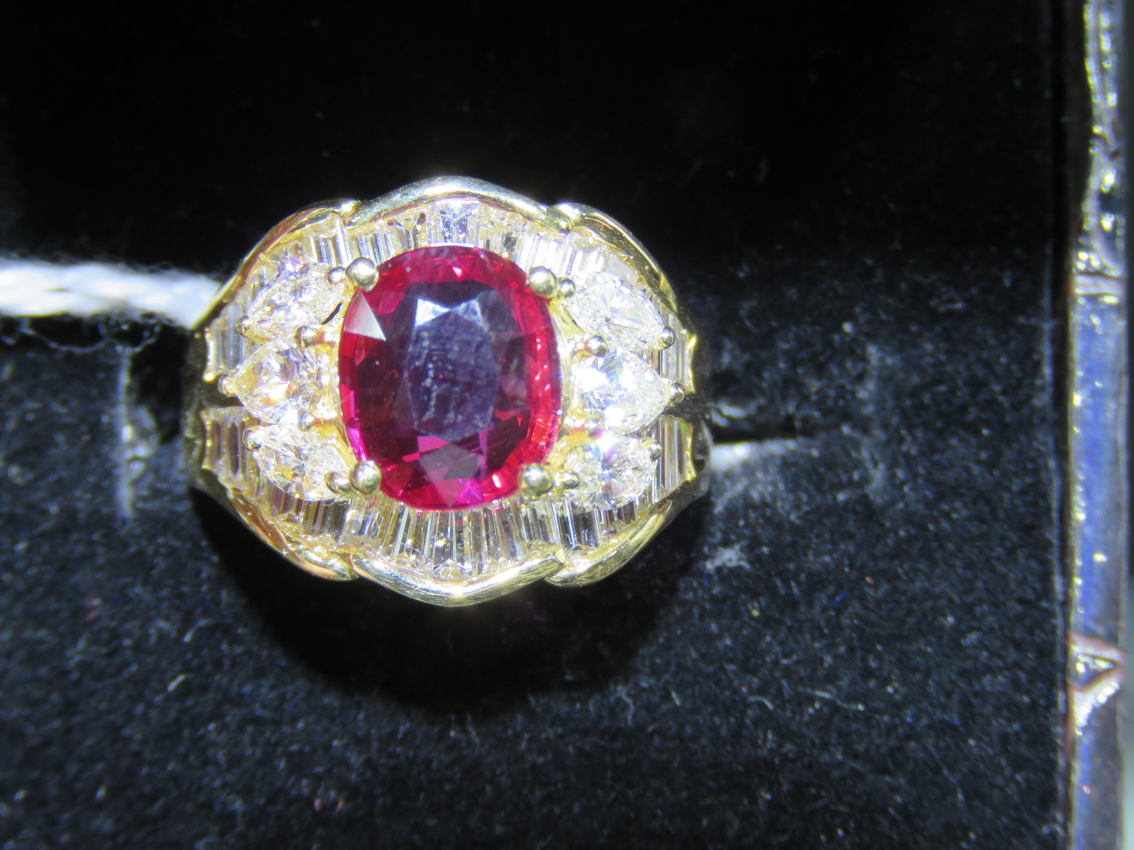 L'article suivant est une bague importante et rare en or jaune 18KT avec un grand rubis et un diamant. La bague est composée d'un magnifique ovale de feu de fantaisie.  Rubis entouré de diamants baguettes et poires exquis et scintillants. A.I.C&W
