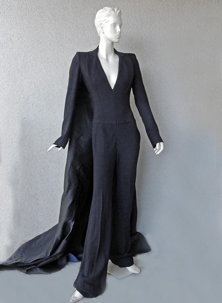 In this 2013 “Finale Tuxedo Jumpsuit with Train” is a design inspired by the tabard cady gown which is a signature silhouette that Antonio Berardi does remarkably well.   

Jumpsuit fashioned as a tuxedo inspired creation with attached long wide