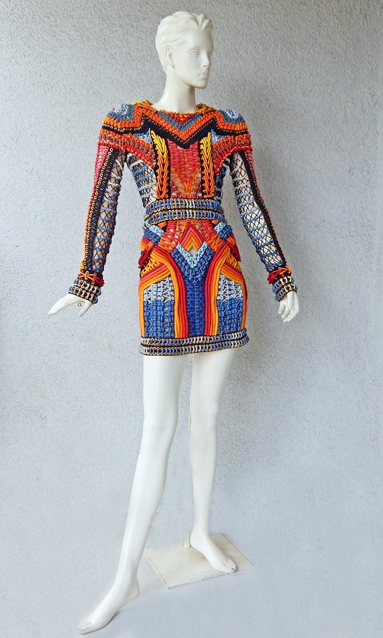 Balmain colorful crochet and macramé dress bordered with gold chain. 

Fabulous multi-hued crocheting!   Special Aztec-inspired artisan hand made garment with graphic weave of colored beaded bands in both crochet and macrame.  Also features zipper