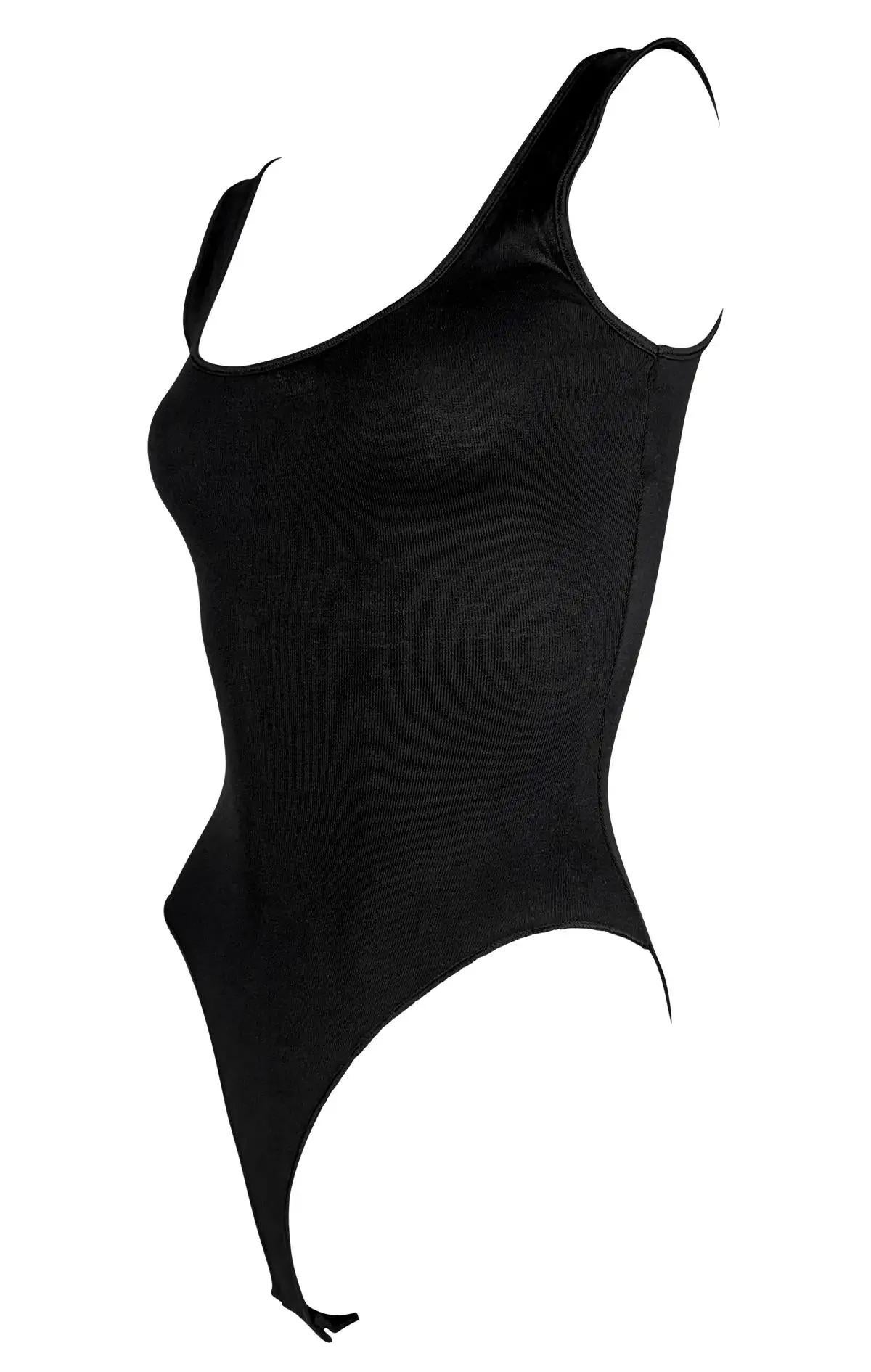 Questo body nero non indossato dei primi anni '90 di Donna Karan presenta una silhouette elegante e aderente al corpo, realizzata in seta. Con un'ampia scollatura a palloncino rifinita in raso e un'apertura delle gambe a taglio alto.

Misure