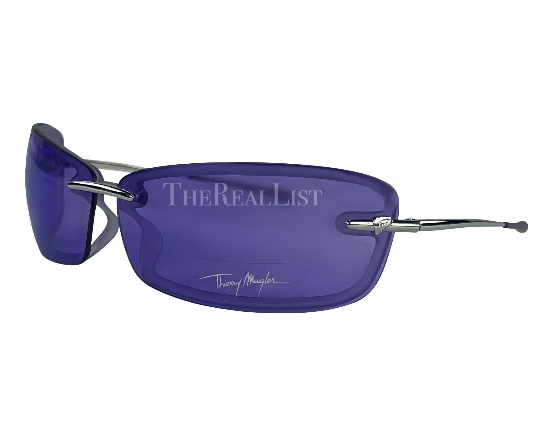 Voici une paire de lunettes de soleil Thierry Mugler d'un violet incroyable, conçue par Manfred Mugler. Datant du début des années 2000, ces lunettes de soleil sans monture sont dotées de verres rectangulaires violets et de branches argentées.