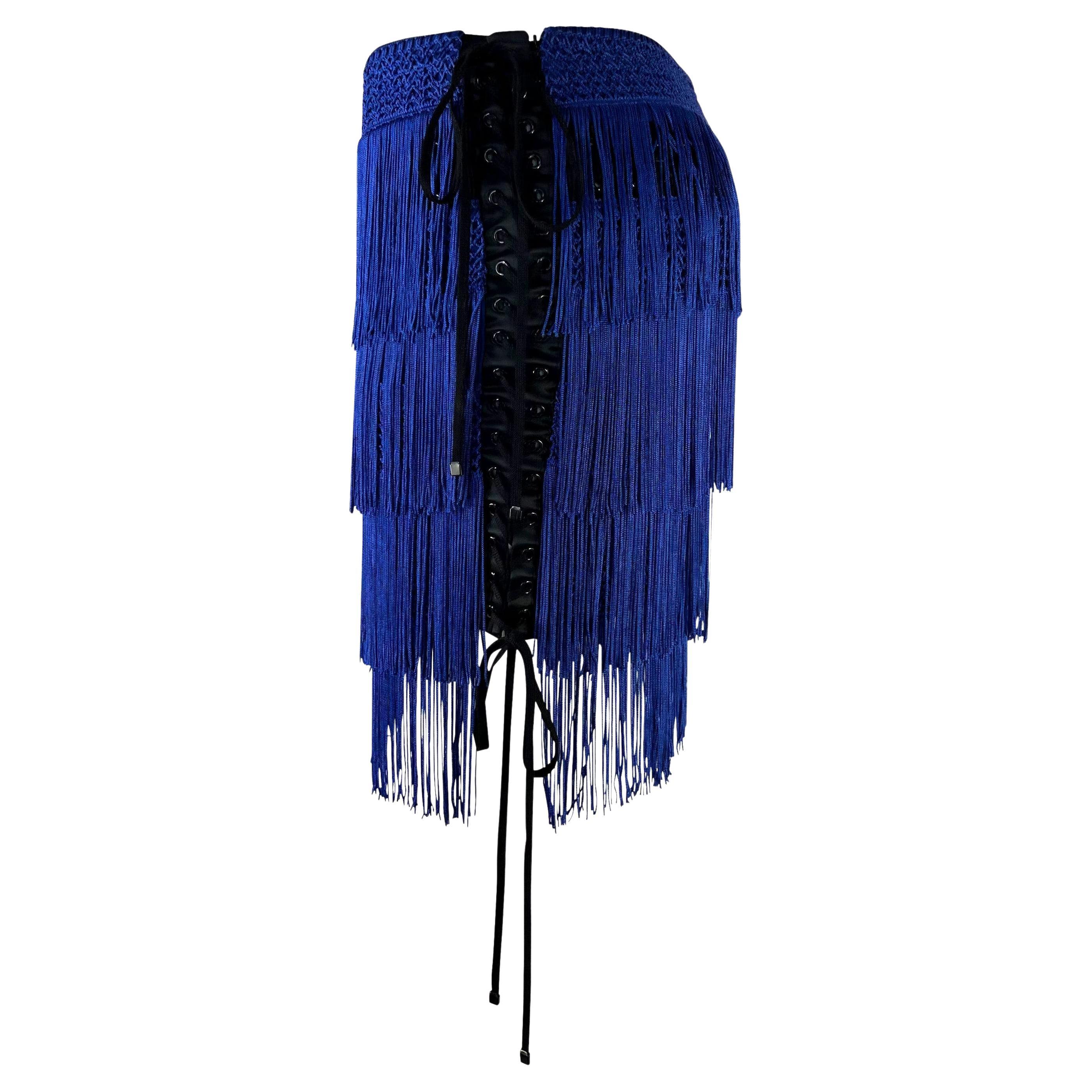 Presenting an electric blue fringe Dolce and Gabbana mini skirt. From the Fall/Winter 2003 collection, this vibrant skirt features layers of fringe with lace-up corset-style detailing. Similarly constructed pieces were presented on the season's