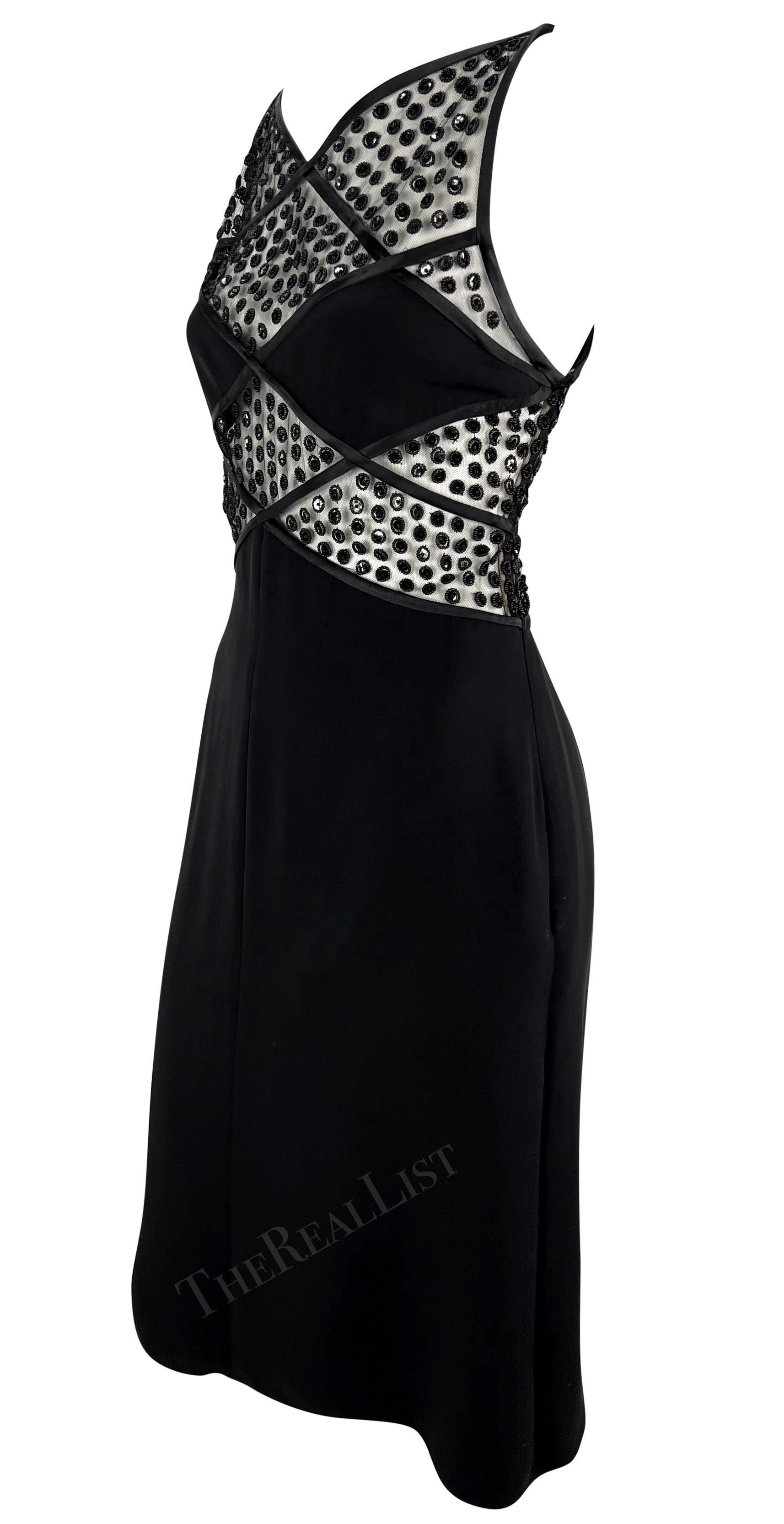 Voici une fabuleuse mini robe noire Valentino de la collection automne/hiver 2004. Cette robe ultra sexy présente des panneaux en forme de diamant au-dessus de la taille, ornés de grappes de paillettes et de perles cousues à la main. Des panneaux de