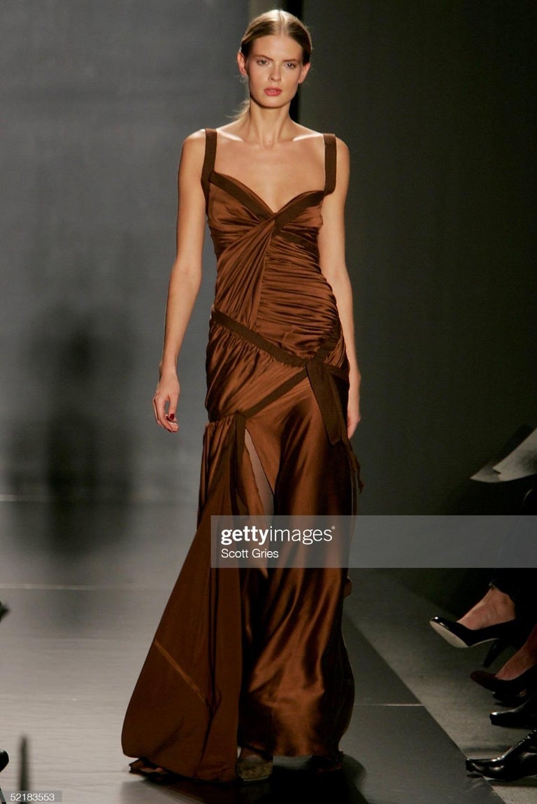 TheRealList presents: a stunning copper brown silk satin evening gown designed by Donna Karan for her Fall/Winter 2005 collection. A version of this piece debuted on the season's runway as look 43, modeled by Julia Stegner. Strips of brown stretch