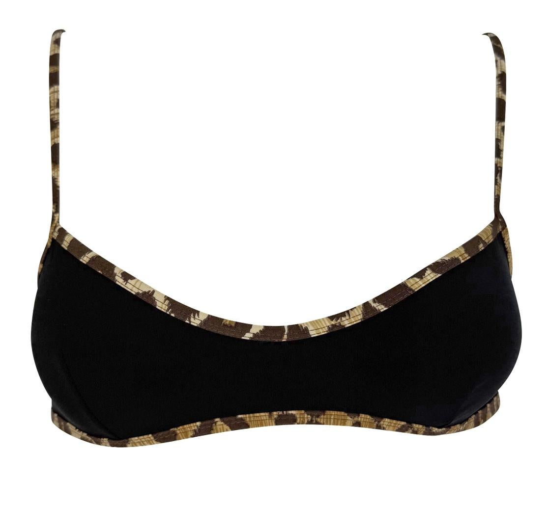 This unworn black bikini swim set from the late 1990s by Dolce & Gabbana features a minimalist silhouette with a straight-across top and classic low-rise bottoms. Both pieces are trimmed with the house’s iconic leopard print. 

Approximate