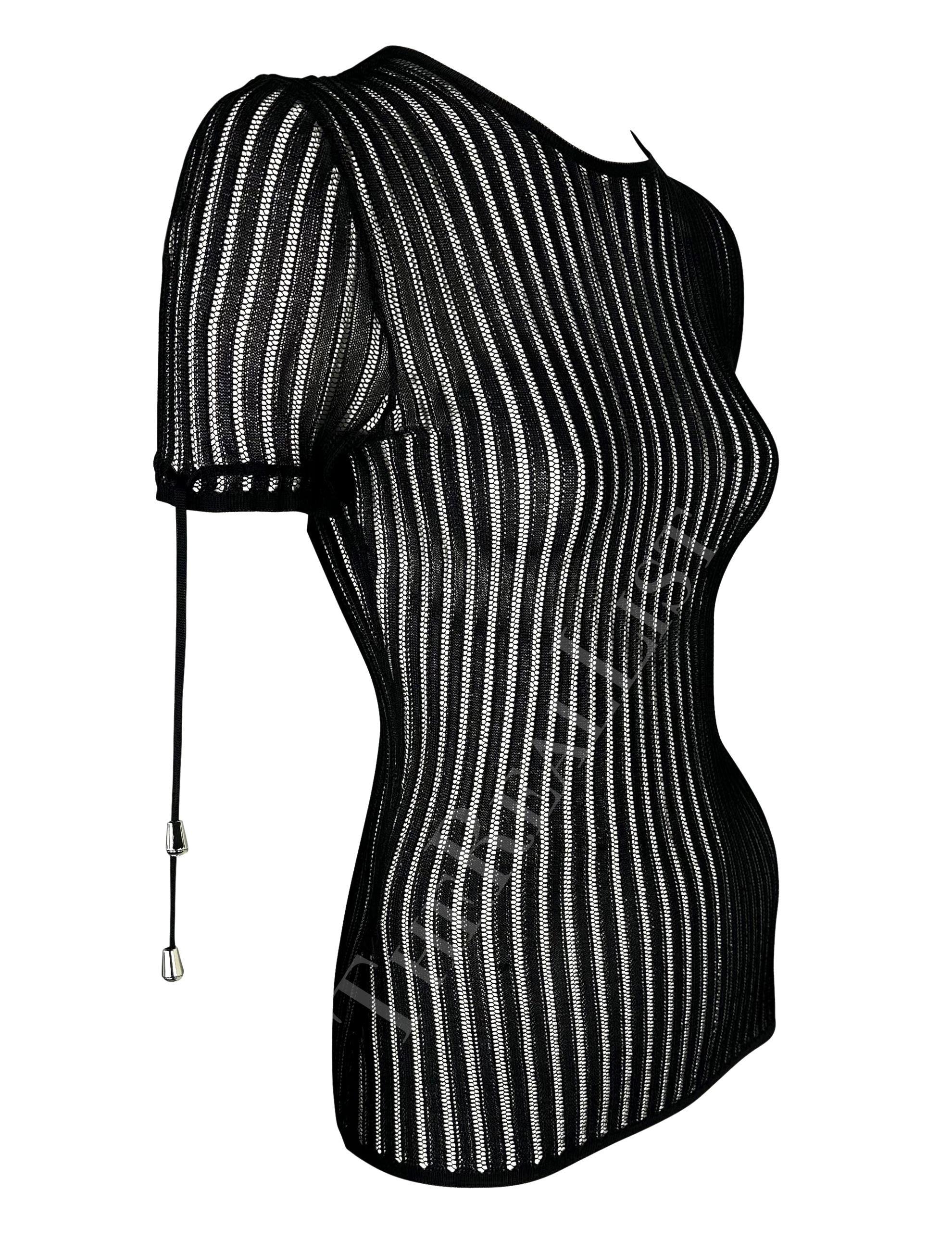Te presentamos un fabuloso top negro de punto Versace de manga corta, diseñado por Donatella Versace. De mediados de la década de 2000, este top de punto transparente presenta detalles de encaje en los puños y un cierre de botones en el cuello. Este