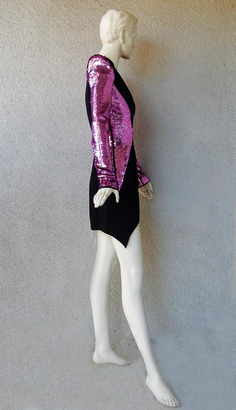 Mugler form-fitting short evening dress with plunging neckline and inverted hemline.  Adorned with Atomic deep pink sequins on a black crepe ground.  Padded shoulders. Designed for a strong and impactful presence.  A real head turner in its dramatic