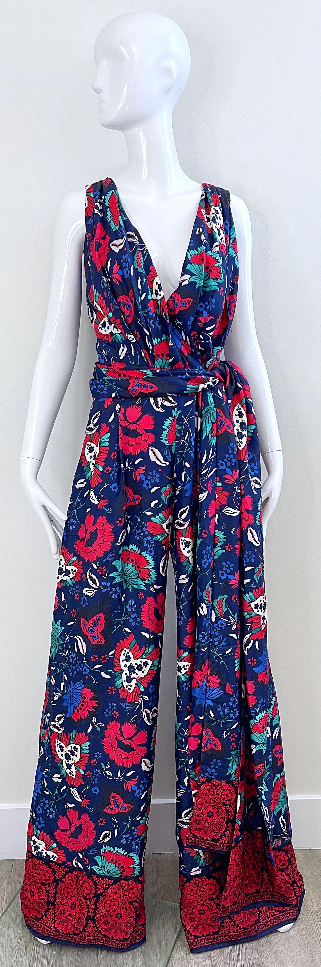 Brand new with tags OSCAR DE LA RENTA wide leg plunging silk jumpsuit ! Features a navy blue background with bright colors of red, turquoise, teal, and white throughout. Pockets at each side of the hips. Hidden zipper up the back with hook-and-eye