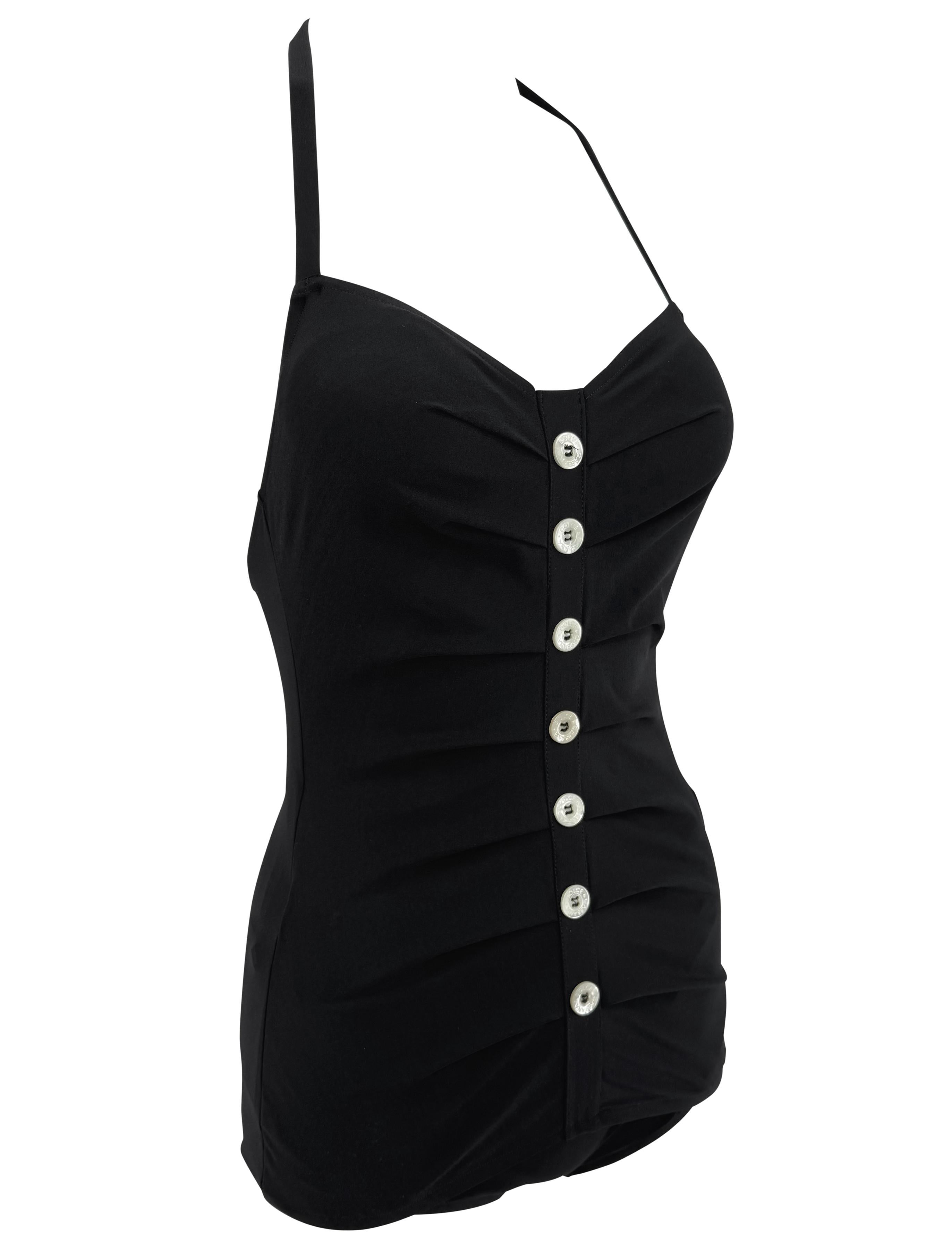 Dieser schwarze einteilige Badeanzug aus der Frühjahr/Sommer-Kollektion 1996 von Dolce & Gabbana zeichnet sich durch strukturierte Falten und eine Reihe kontrastierender weißer Knöpfe auf der Vorderseite aus. Dieser neue Badeanzug ist mit einem
