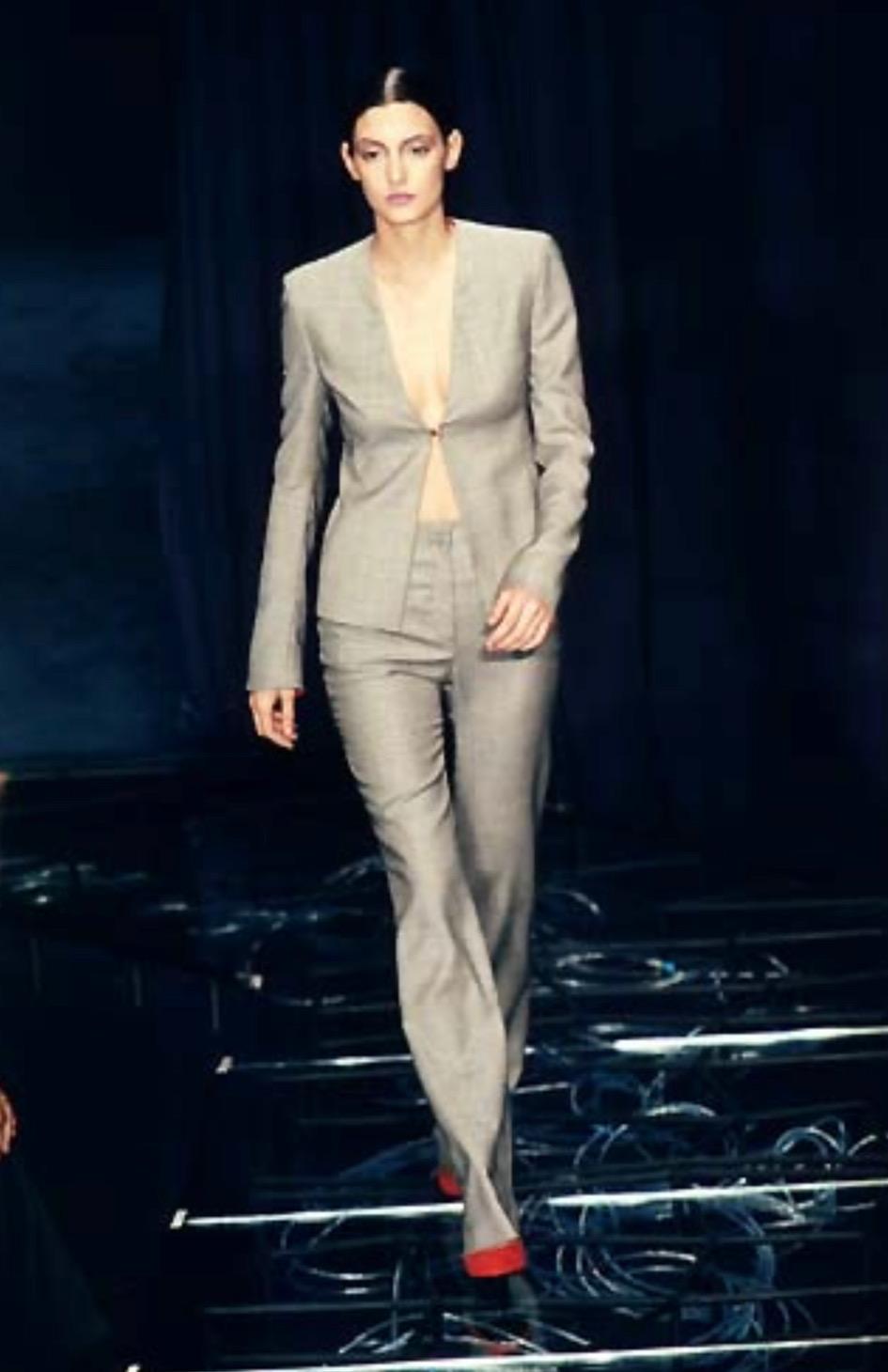 Presenting a fabulous grey houndstooth Gianni Versace tunic suit designed by Donatella Versace. From the Spring/Summer 1998 collection, a similar open-front jacket debuted on the season's runway. This fabulous set is comprised of a tunic-style coat